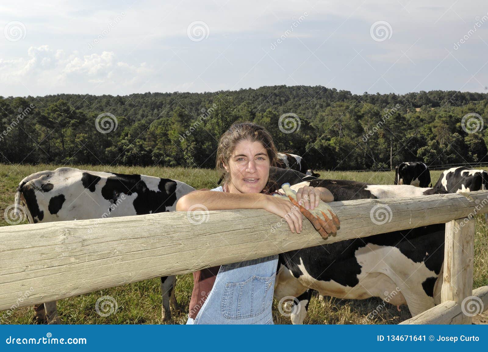 portrait of a farmer with her cows in the field