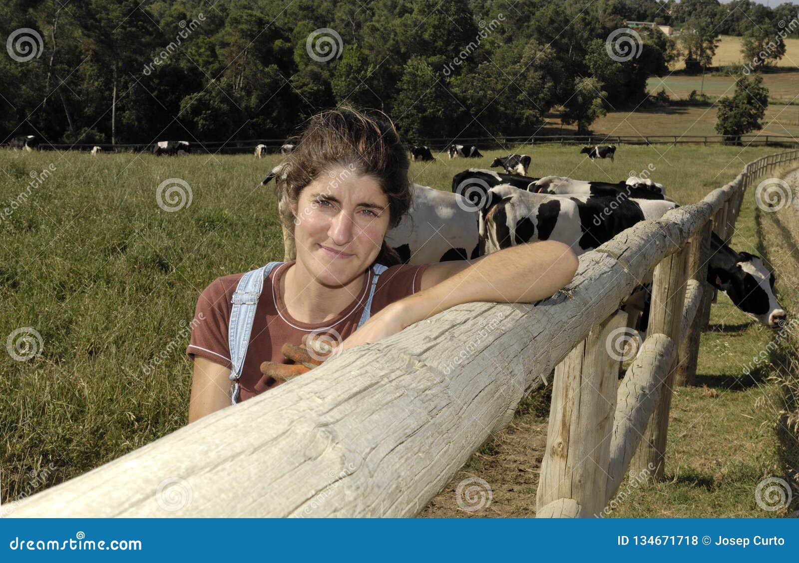 portrait of a farmer with her cows in the field