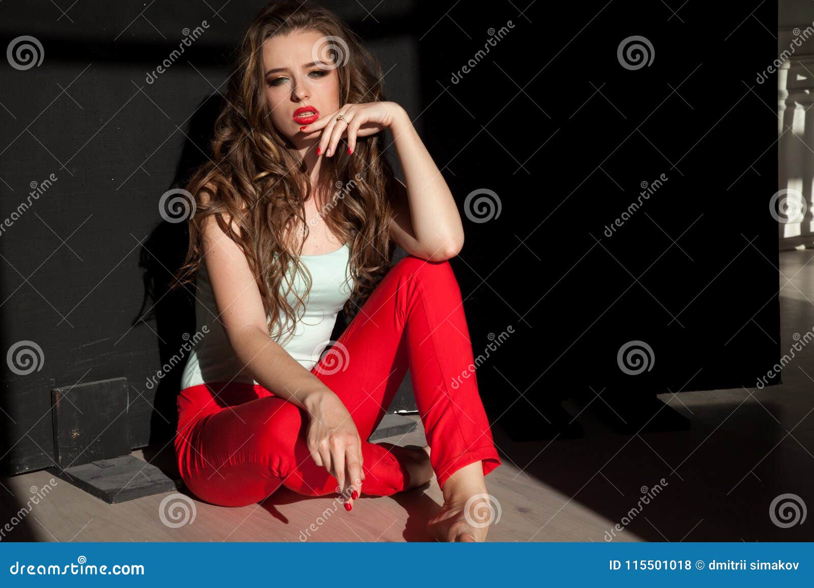 portrait of fashionable girl in red pants on a black background