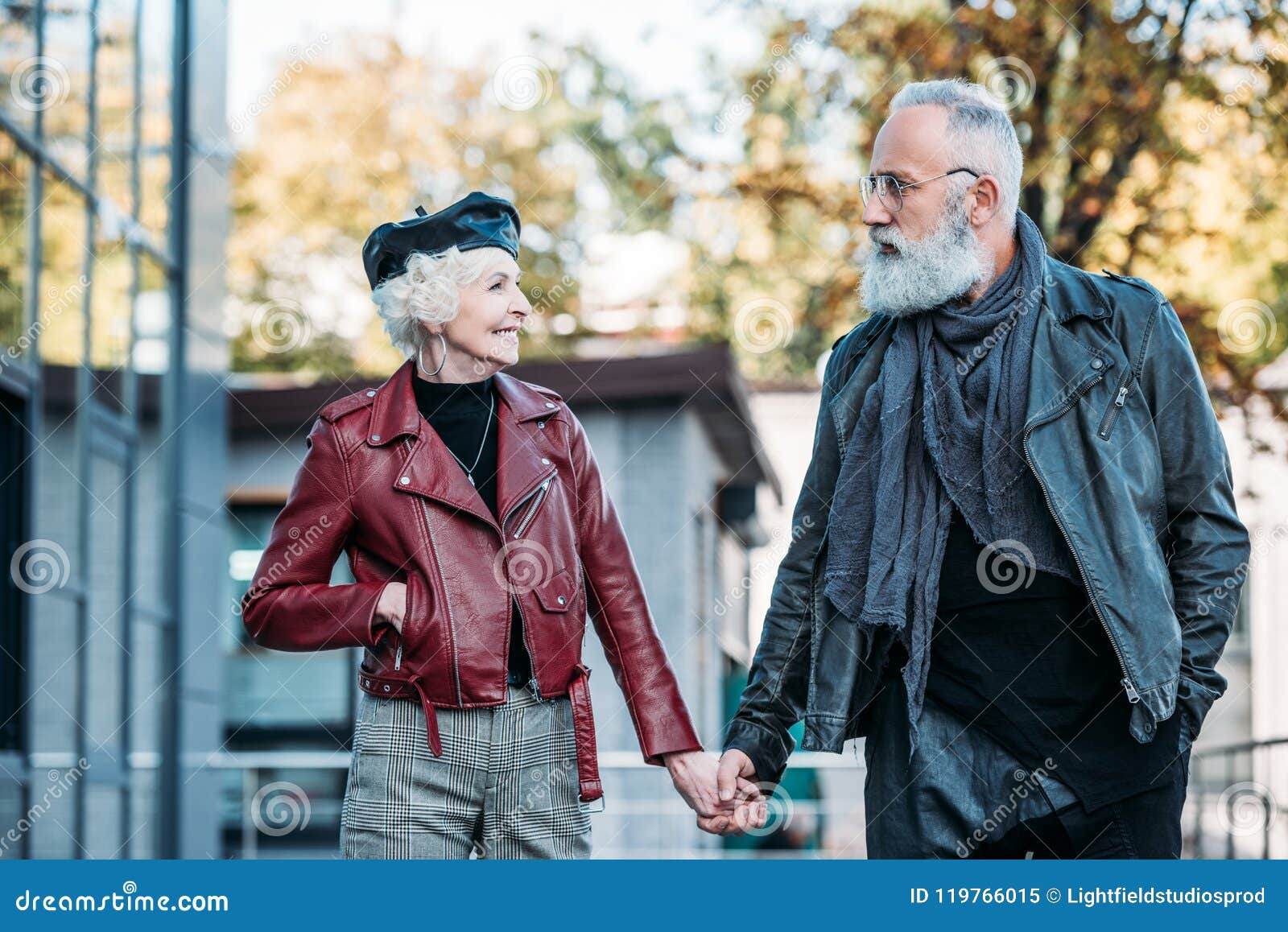 portrait of fashionable senior couple holding hands and looking at each other