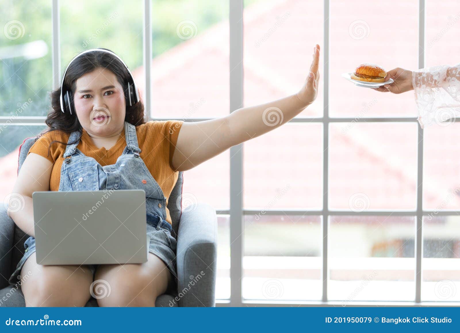 chubby girl with headphones on couch