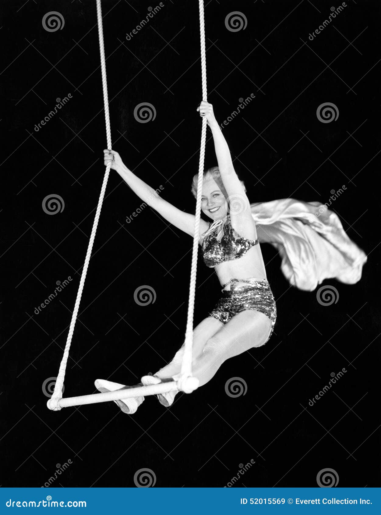 portrait of a female circus performer performing on a trapeze bar