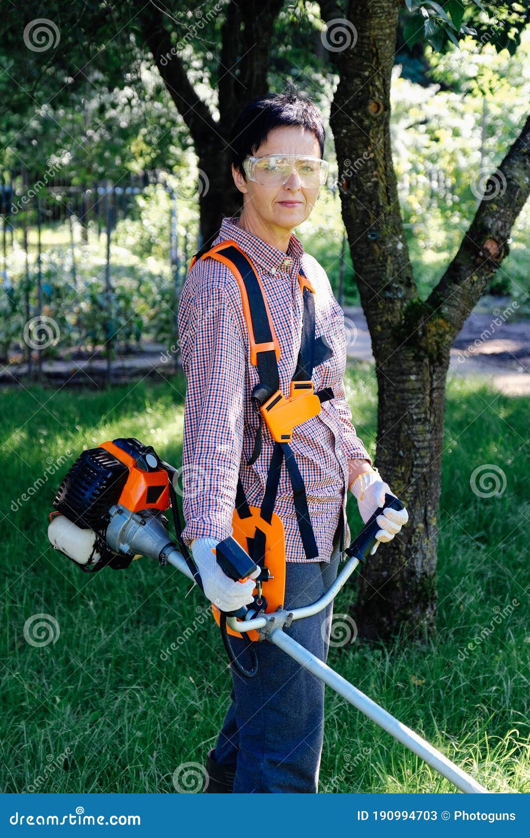 Portrait of Female Gardener with Grass Trimmer in the Backyard. Garden ...