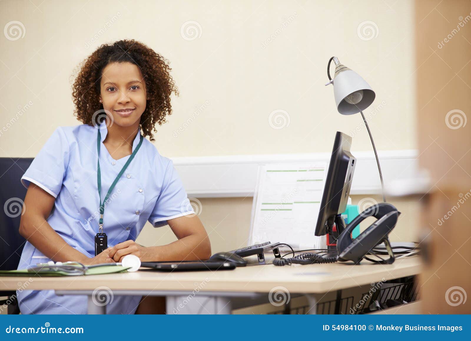 Portrait of Female Nurse Working at Desk in Office Stock Photo Image