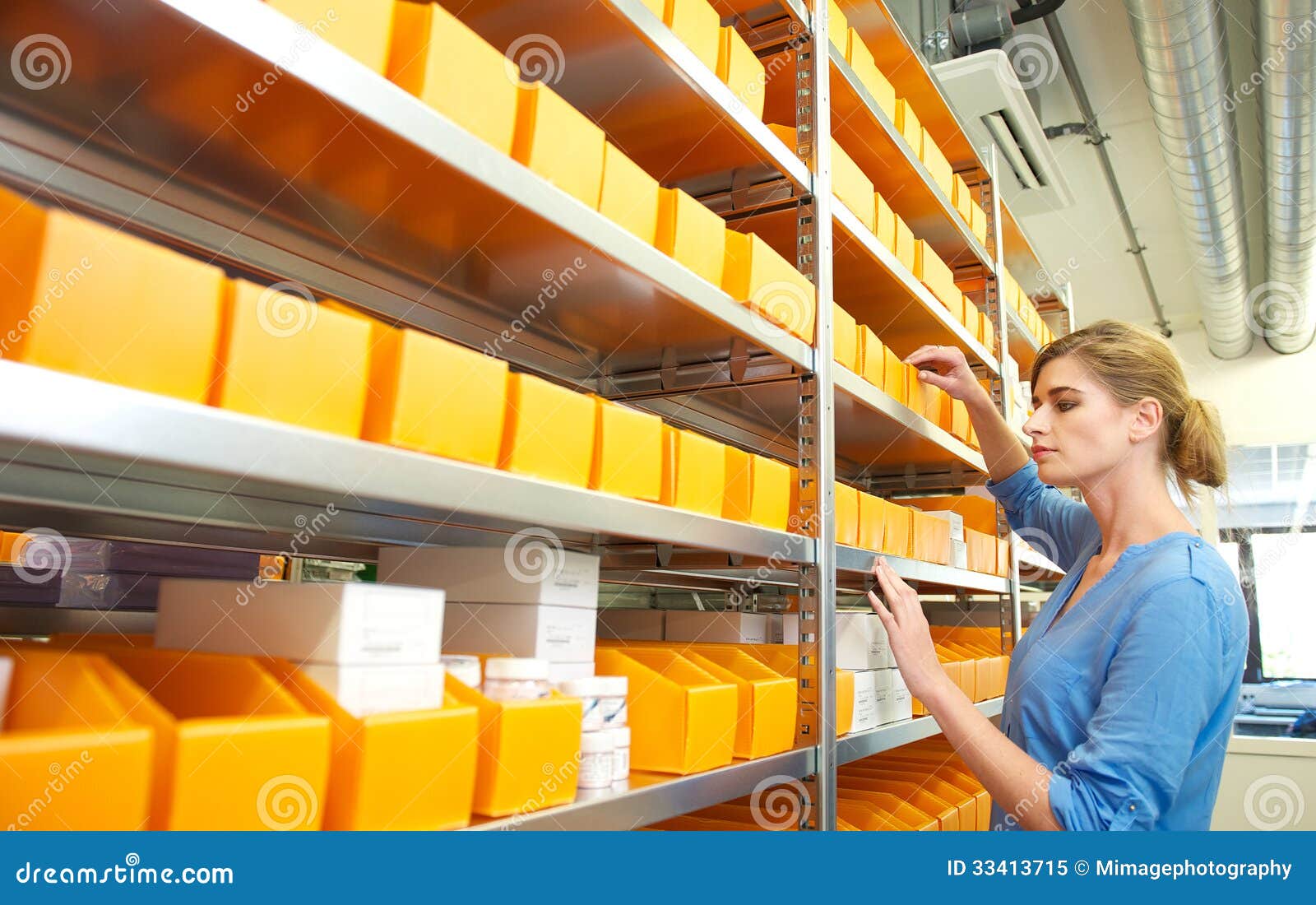portrait of a female worker organizing boxes on shelves