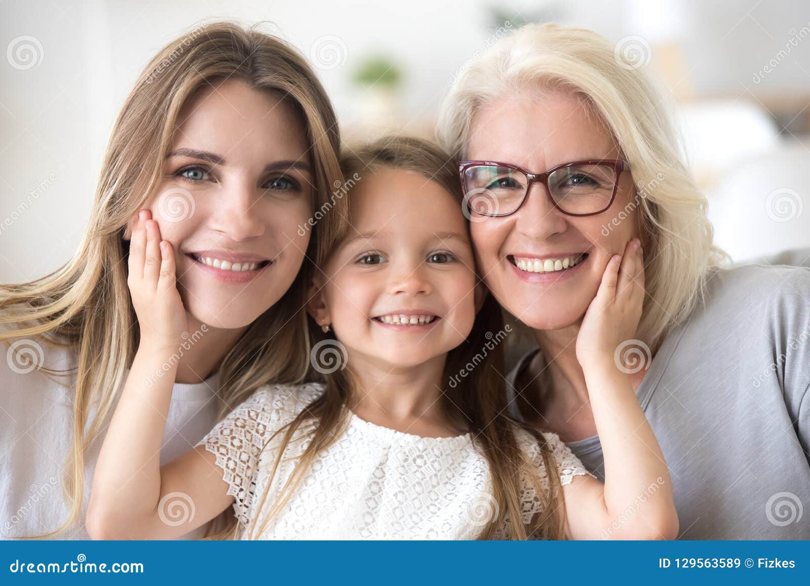 portrait of girl hugging mom and grandmother making family pictu