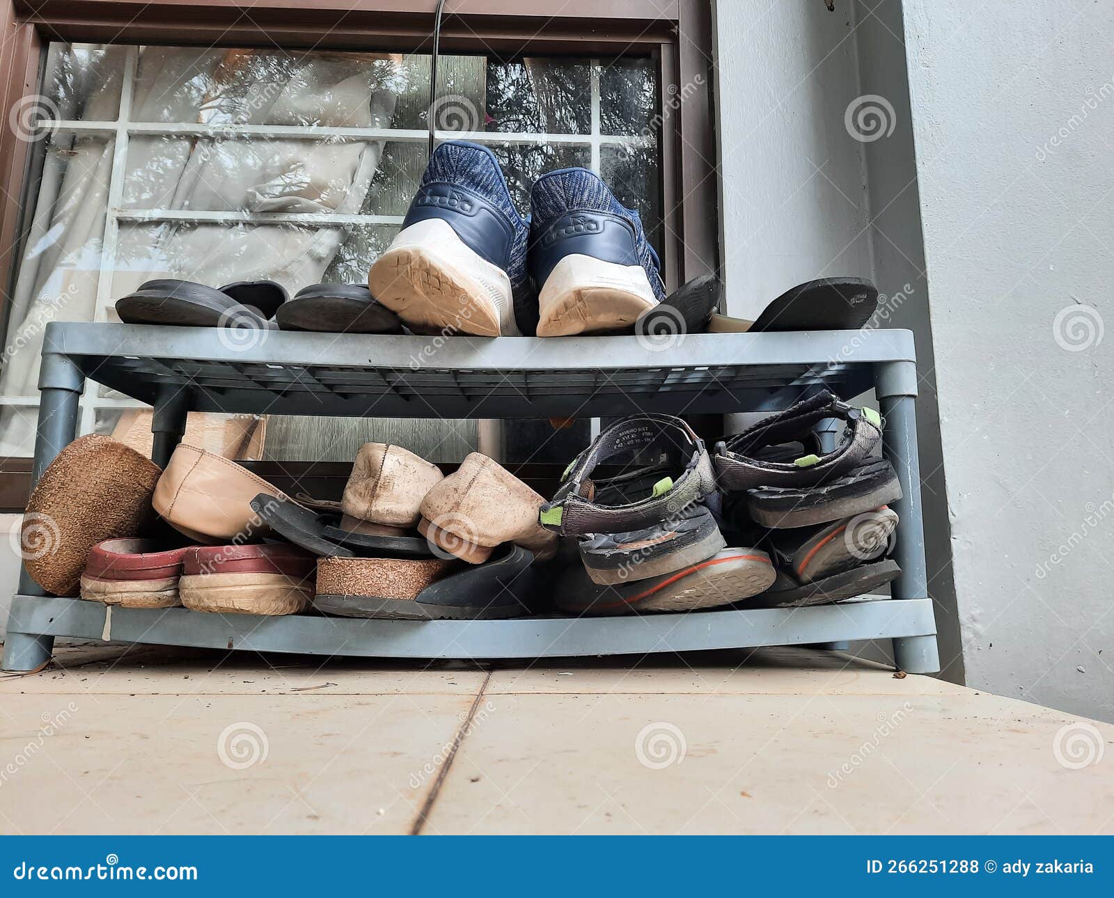 A Portrait of the Gray Shoe Rack Which Contains Lots of Sandals and ...