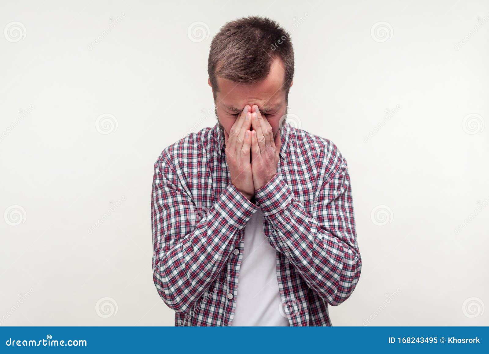 portrait of grieving bearded man hiding face in hands and crying, feeling sorrow. white background