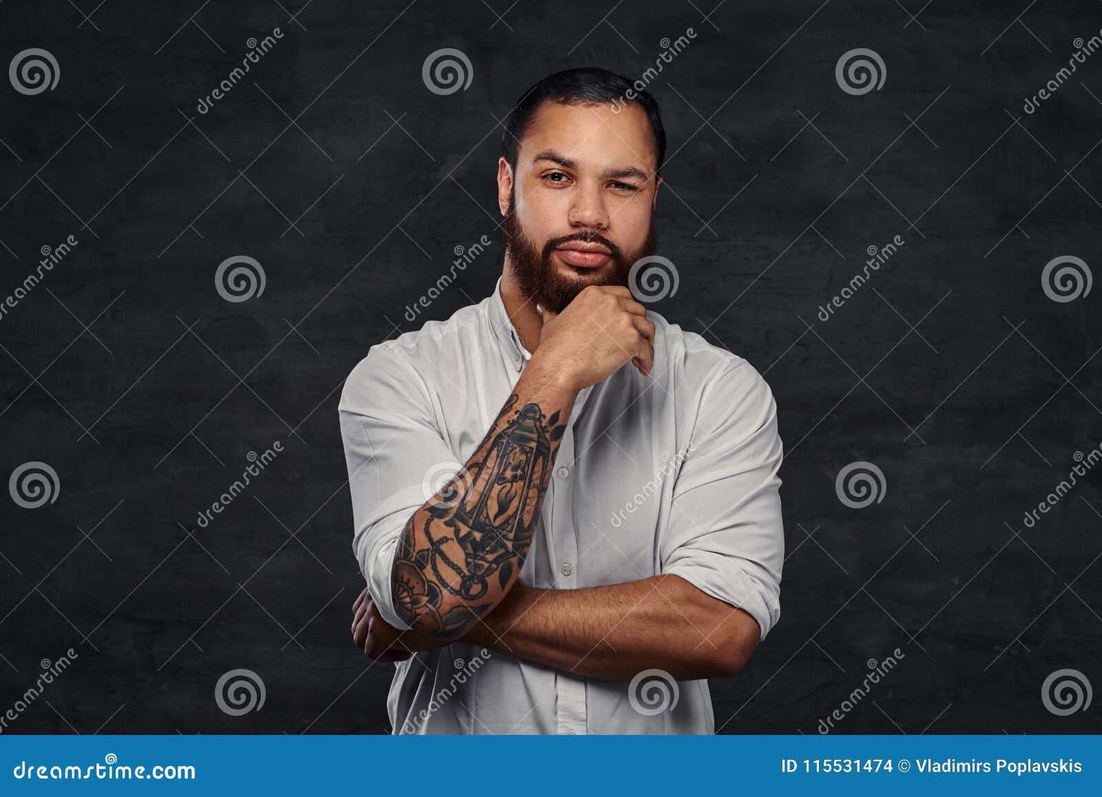 Portrait of a Handsome African-American Tattooed Man with Stylish Hair and Beard in a White Shirt, Holding Hand on His Stock Photo - Image of isolated, brown: 115531474