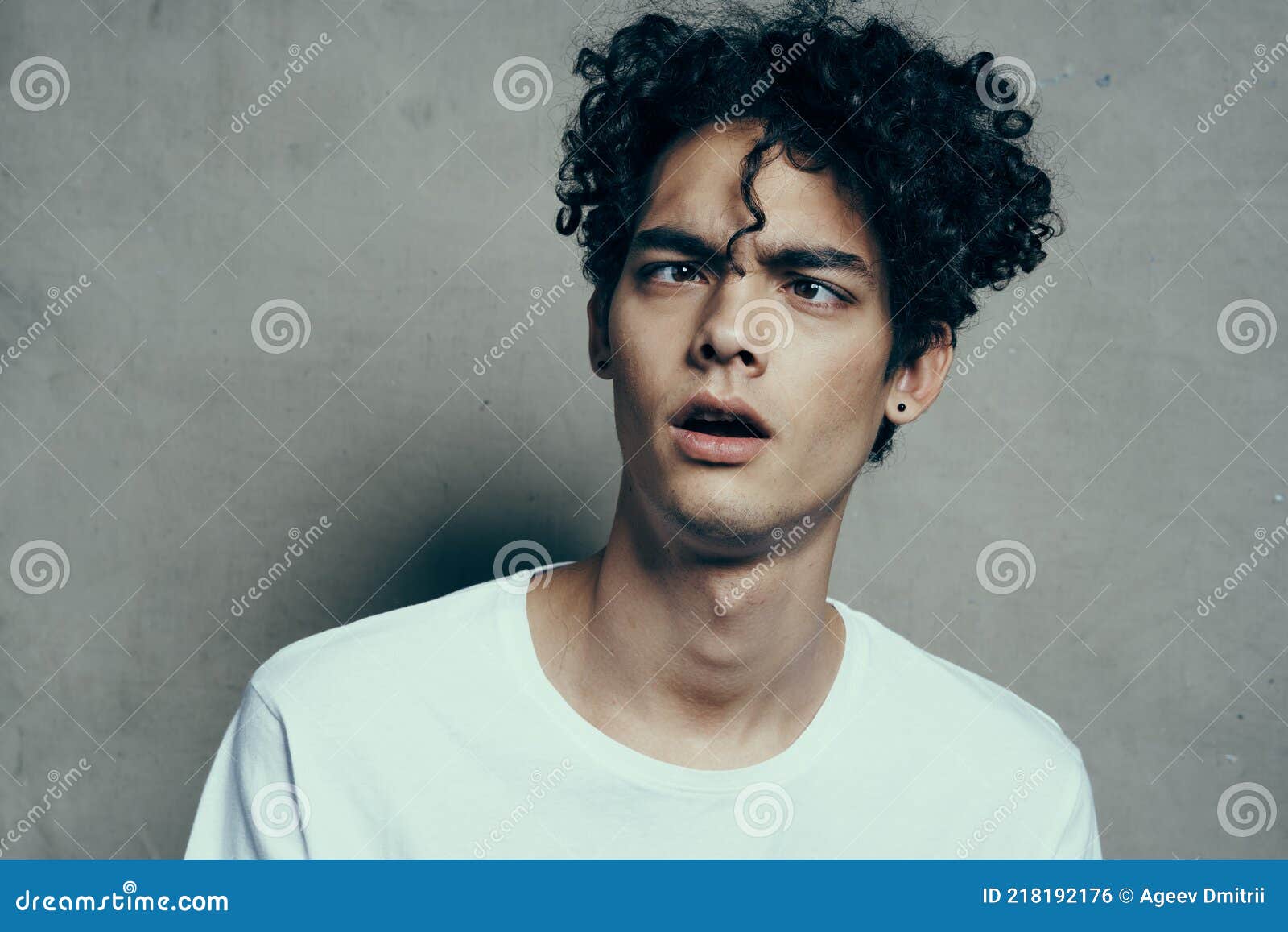 Portrait of a Handsome Guy with Curly Hair on a Gray Background White  T-shirt Close-up Model Stock Photo - Image of anatomy, massage: 218192176