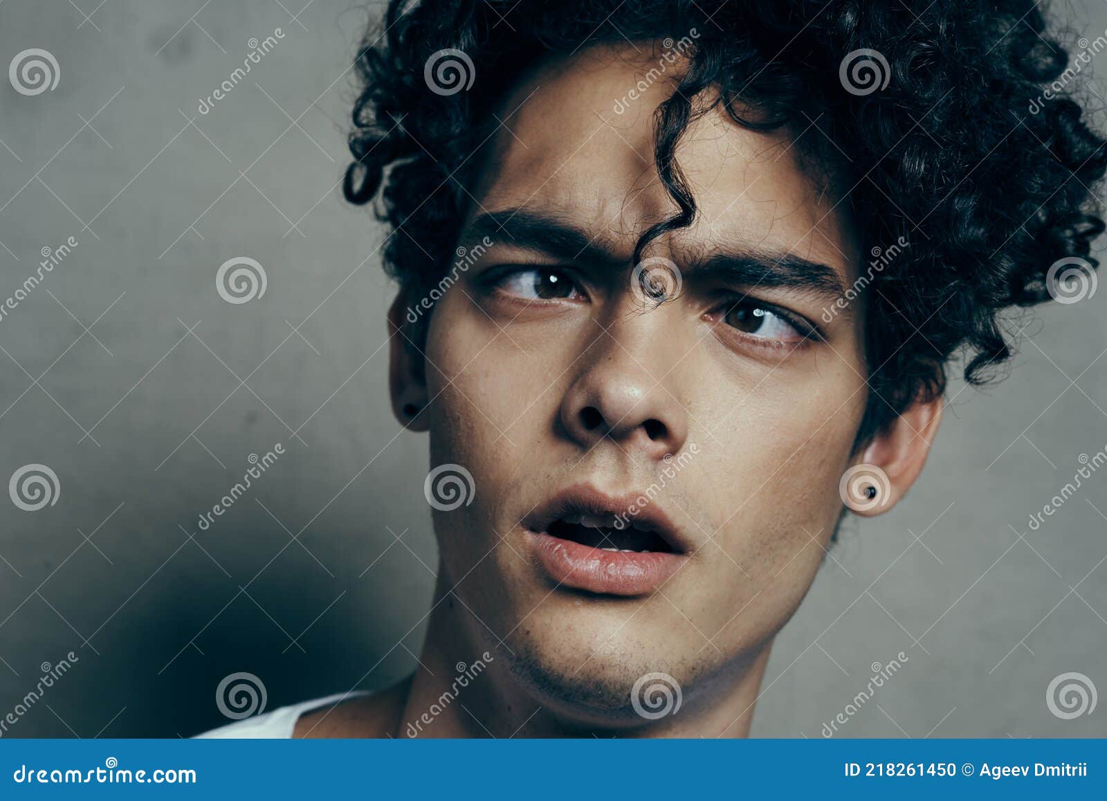 Portrait of a Handsome Guy with Curly Hair on a Gray Background White  T-shirt Close-up Model Stock Photo - Image of anatomy, depressed: 218261450
