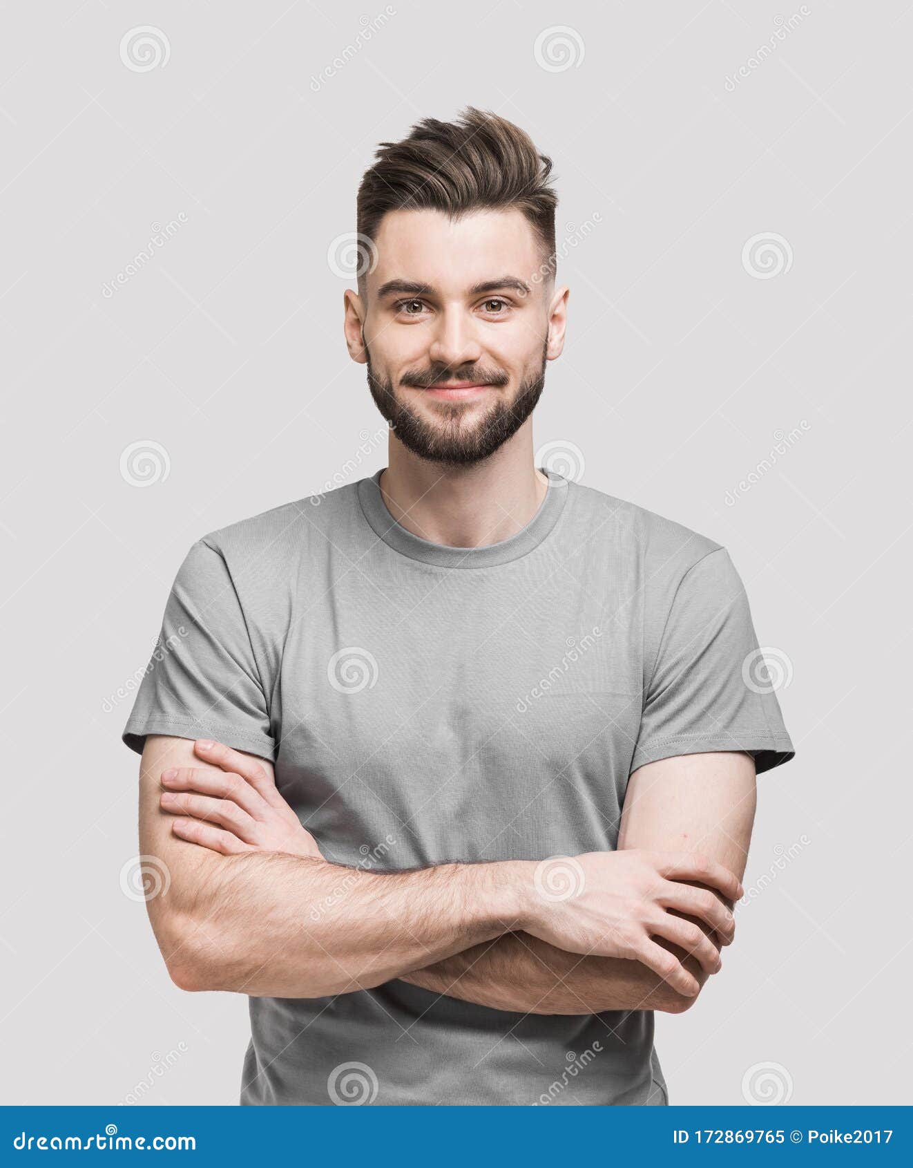 portrait of handsome smiling young man with folded arms. smiling joyful cheerful men with crossed hands  studio shot.