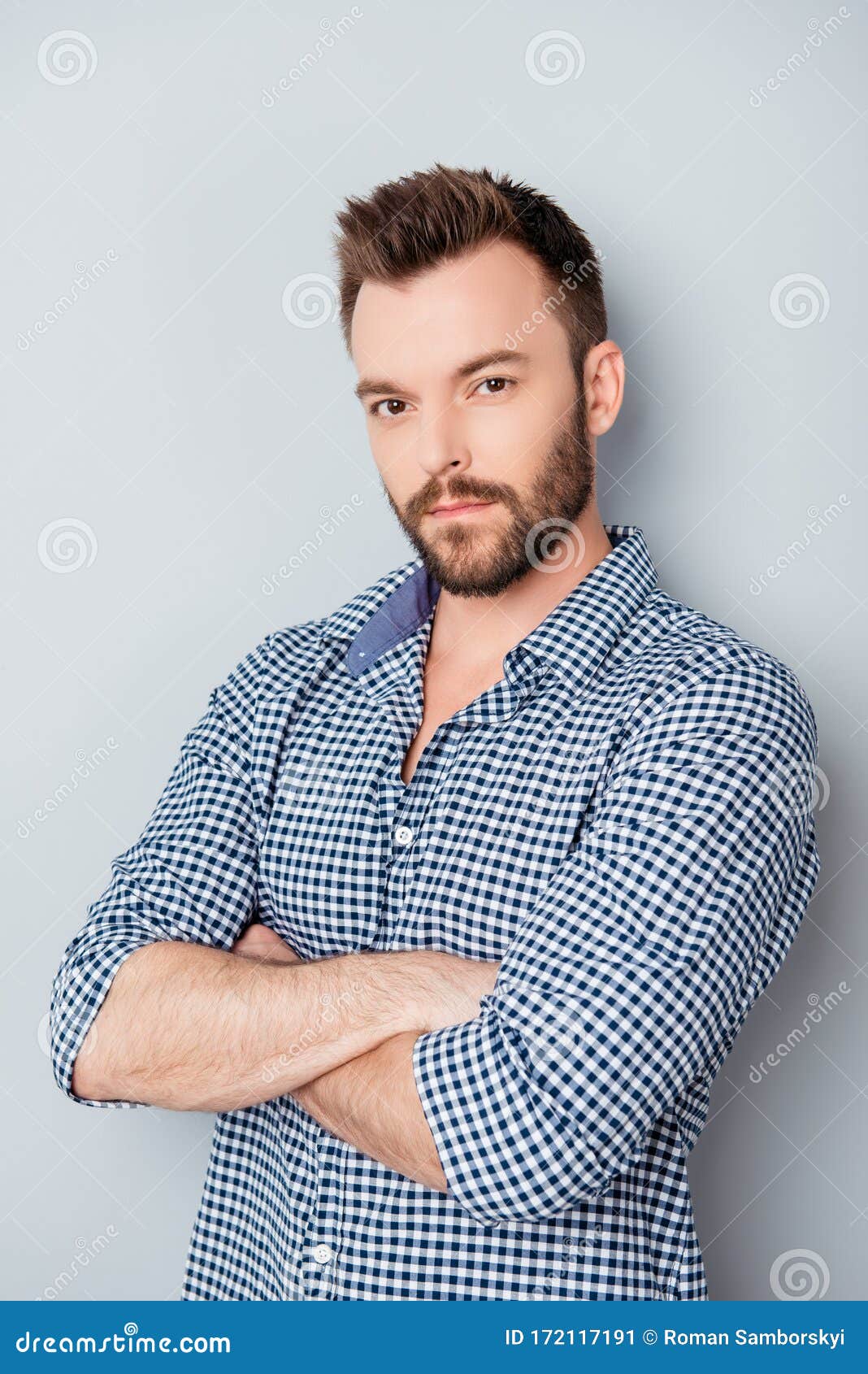 portrait of handsome young minded man with crossed hands