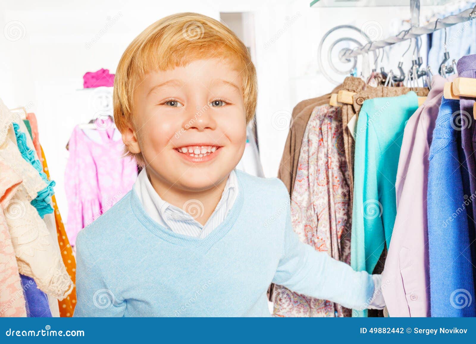 Portrait of Happy Blond Boy Standing Near Hangers Stock Photo - Image ...