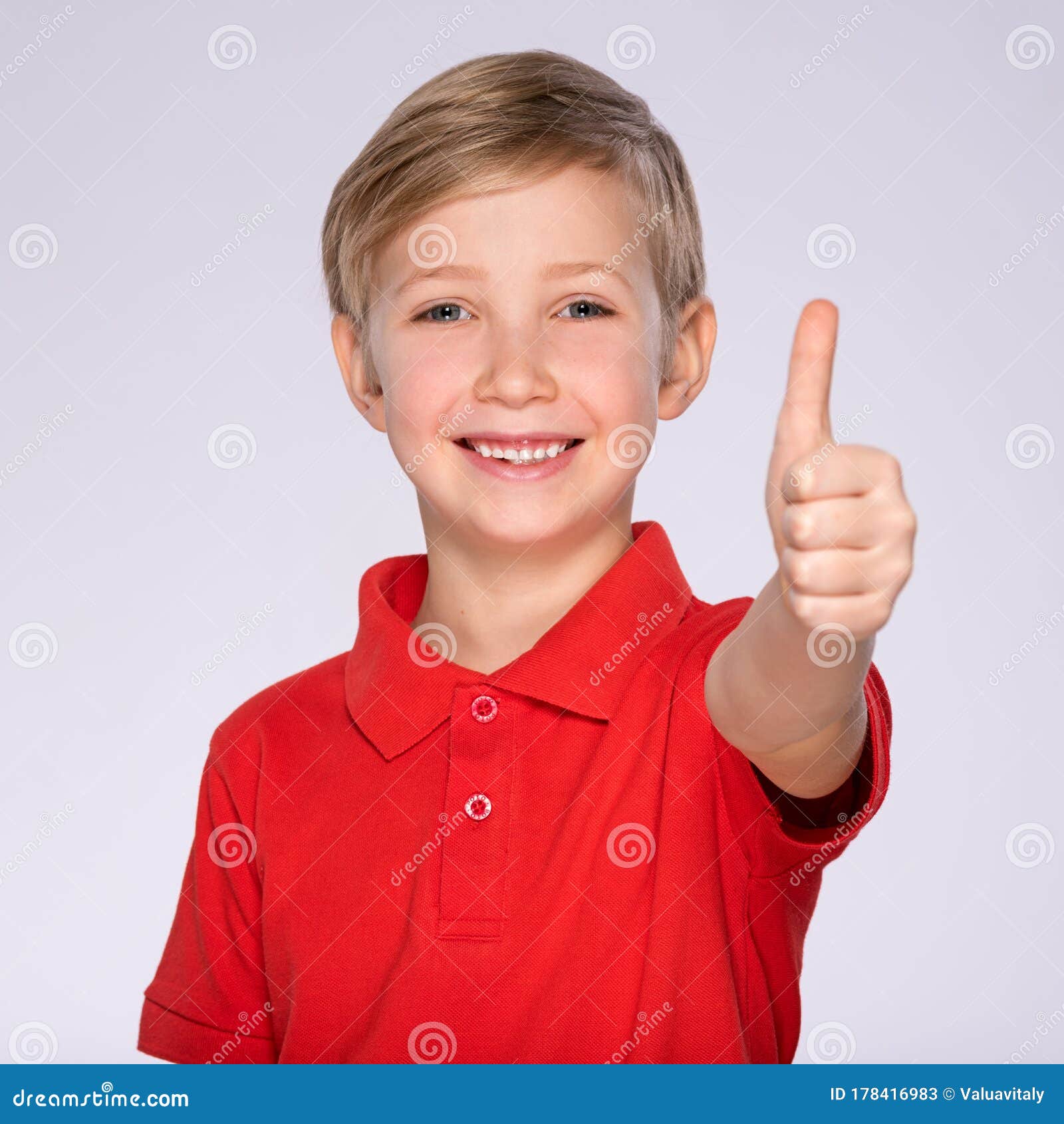 Portrait Of Happy Boy Showing Thumbs Up Gesture Isolated Over White