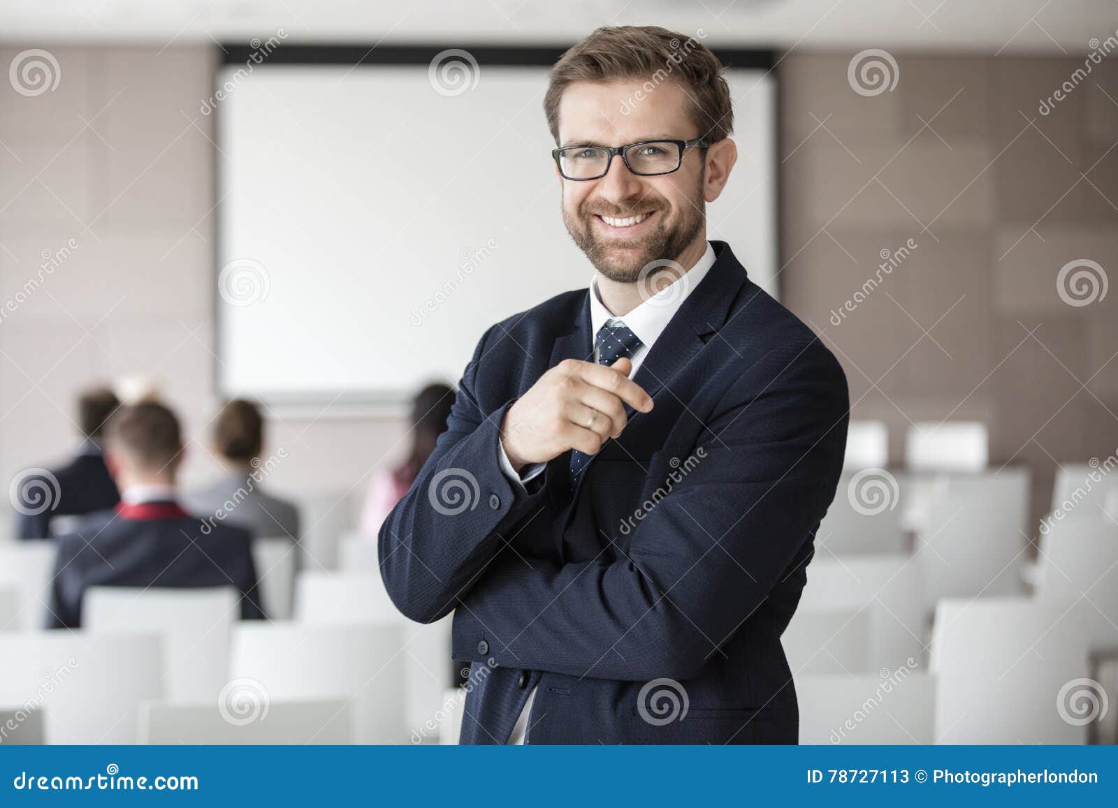 portrait of happy businessman standing in seminar hall