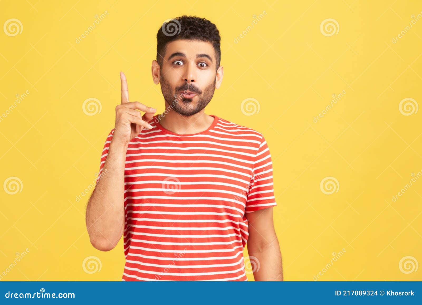 portrait of happy excited man with beard in striped shirt pointing finger up, find out solution or idea, get answer on question,