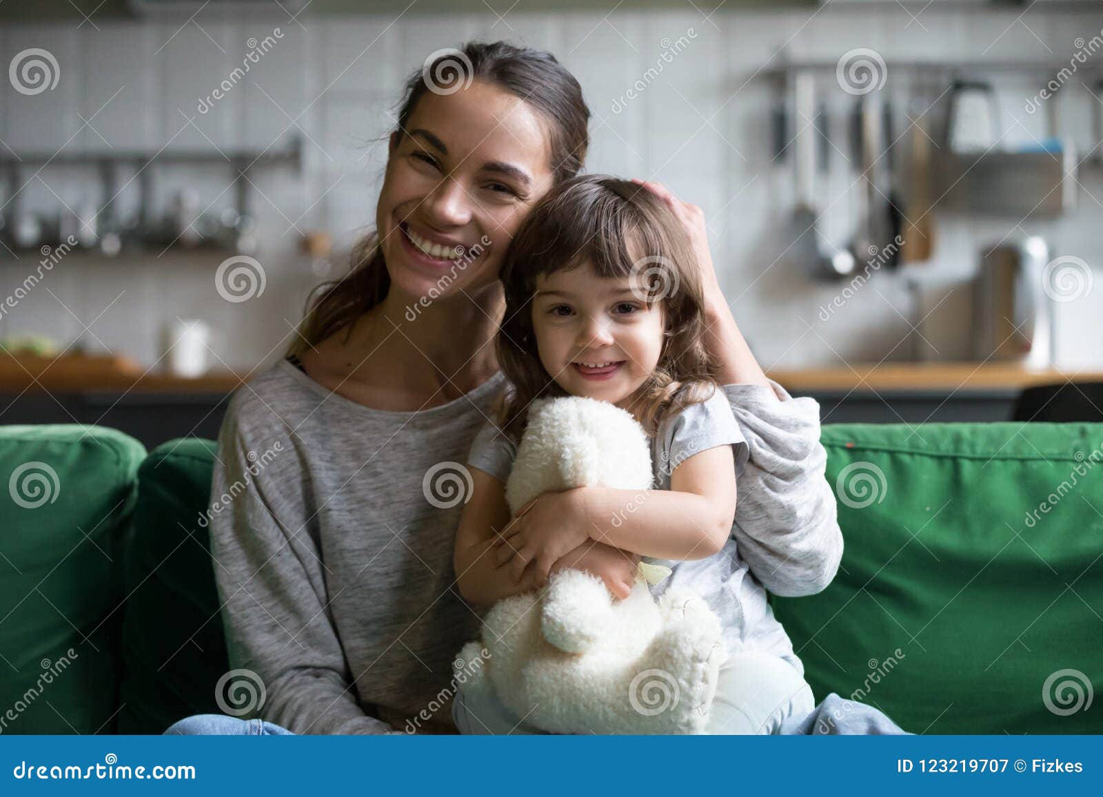 portrait of happy family single mother and kid daughter embracin