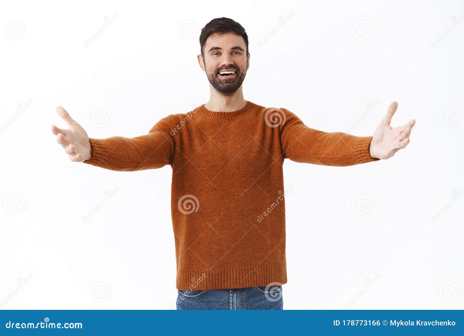 portrait of happy and friendly bearded man give warm welcome to dear guest, spread hands sideways in cuddle or embraces