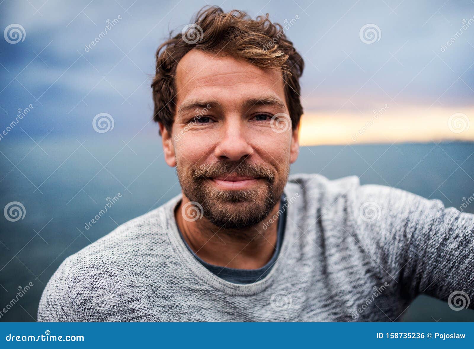 A Portrait of Handsome Man Standing Outdoors, Looking at Camera. Stock ...
