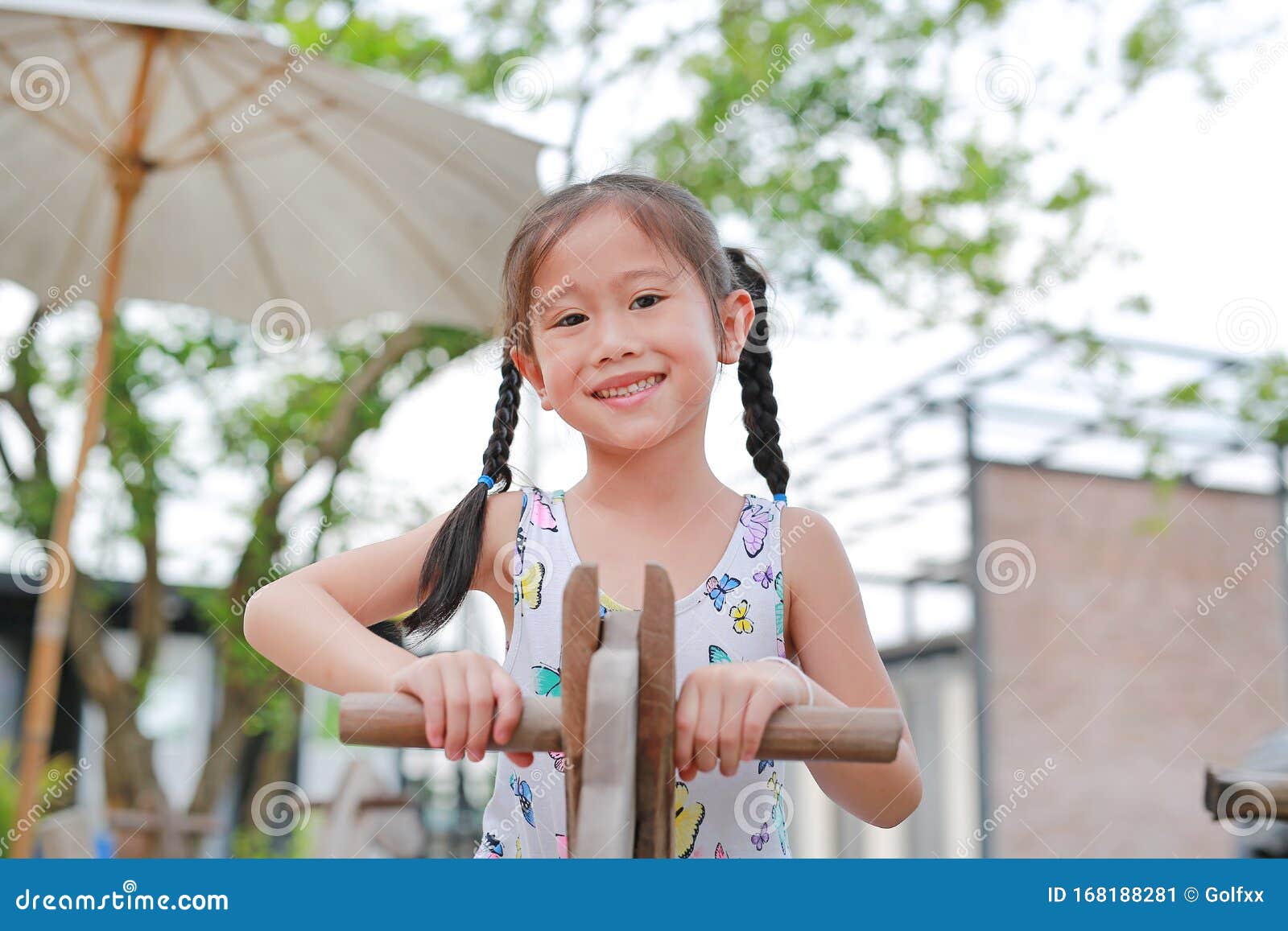 Portrait Of Happy Little Asian Girl Playing Wooden Toy Horse In The