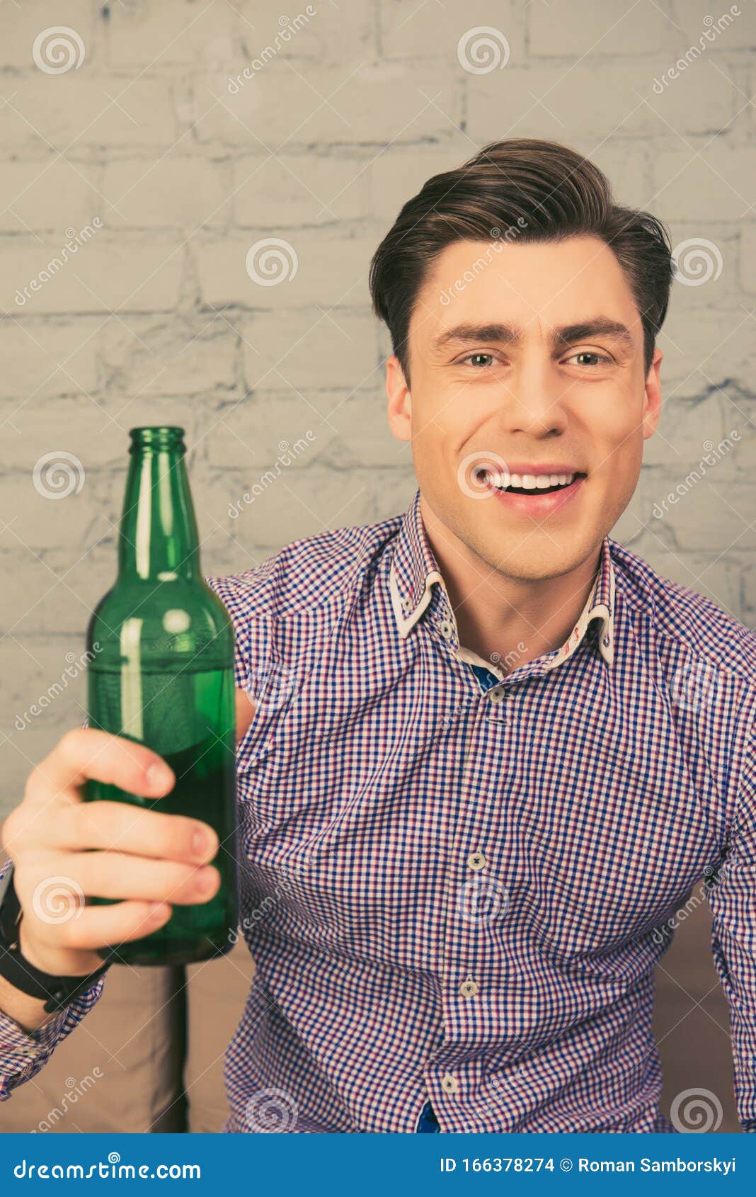 Portrait of Happy Man Sitting on Sofa with Bottle of Beer Stock Photo ...