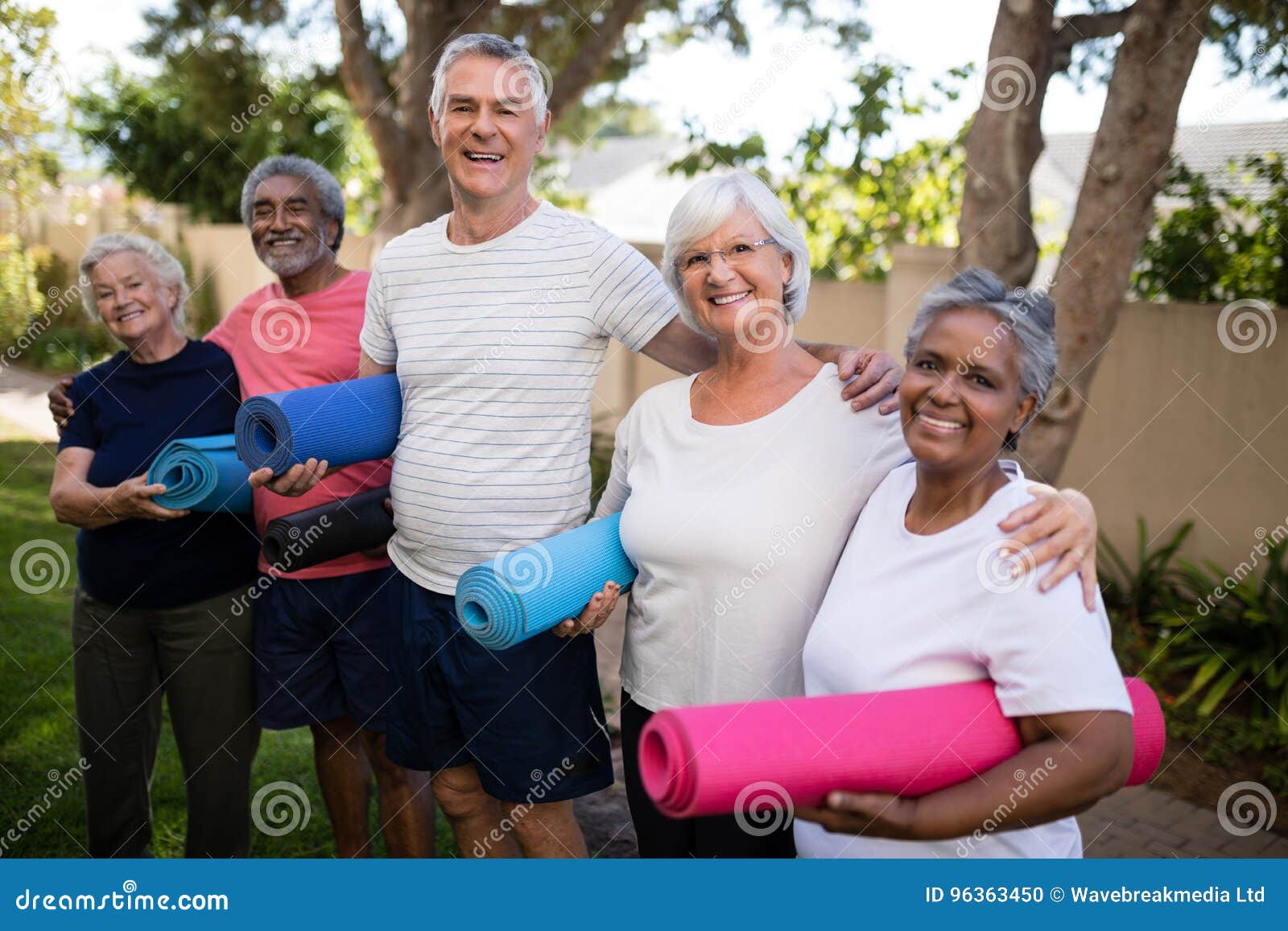 portrait of happy multi-ethnic friends carrying exercise mats