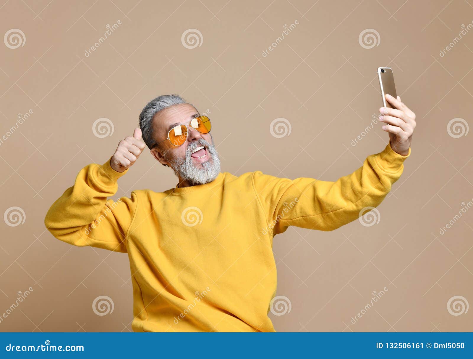 portrait of happy senior millionaire man using smartphone cellphone make selfie in yellow sunglasses