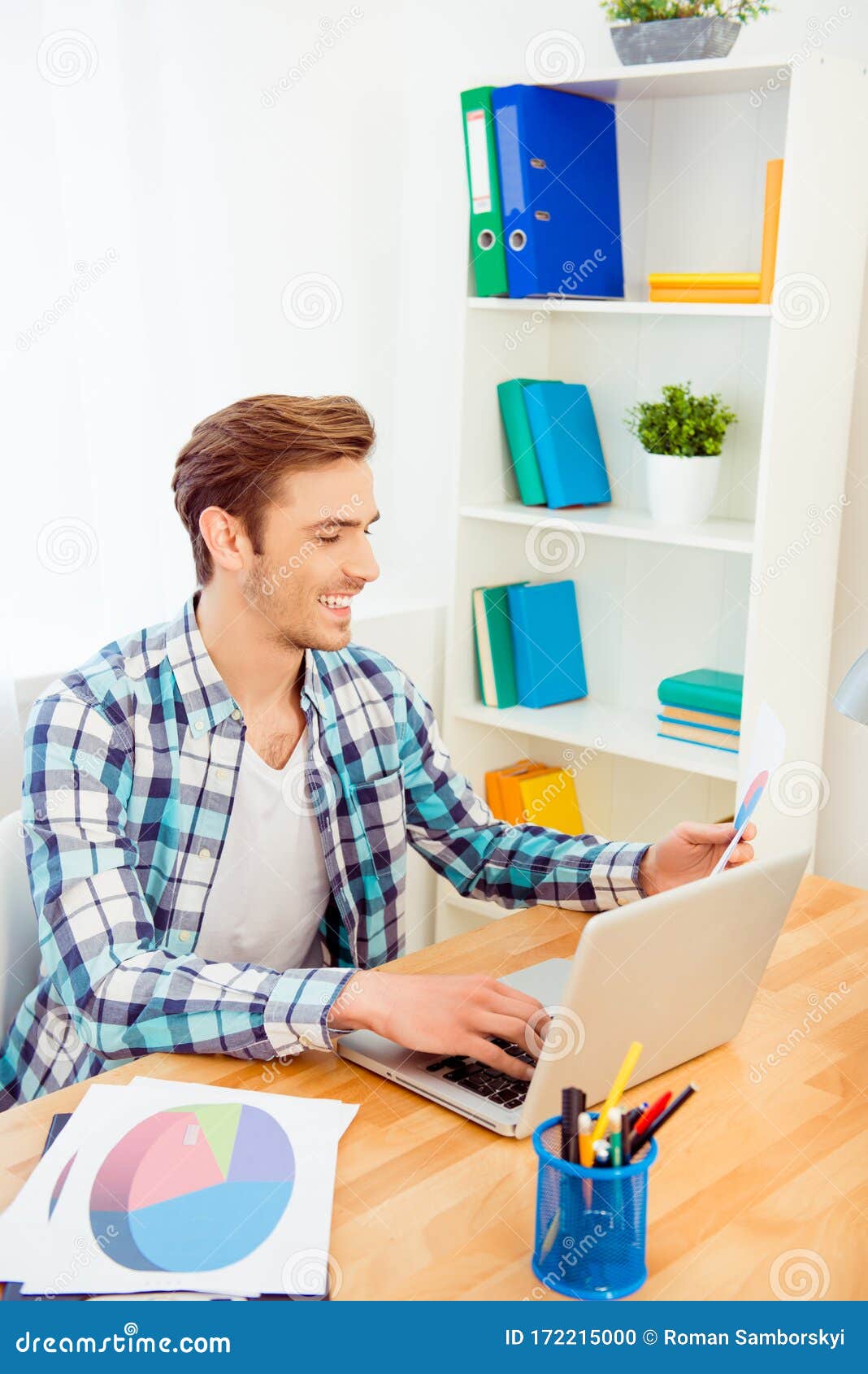 portrait of happy young man working with laptop and diagrama