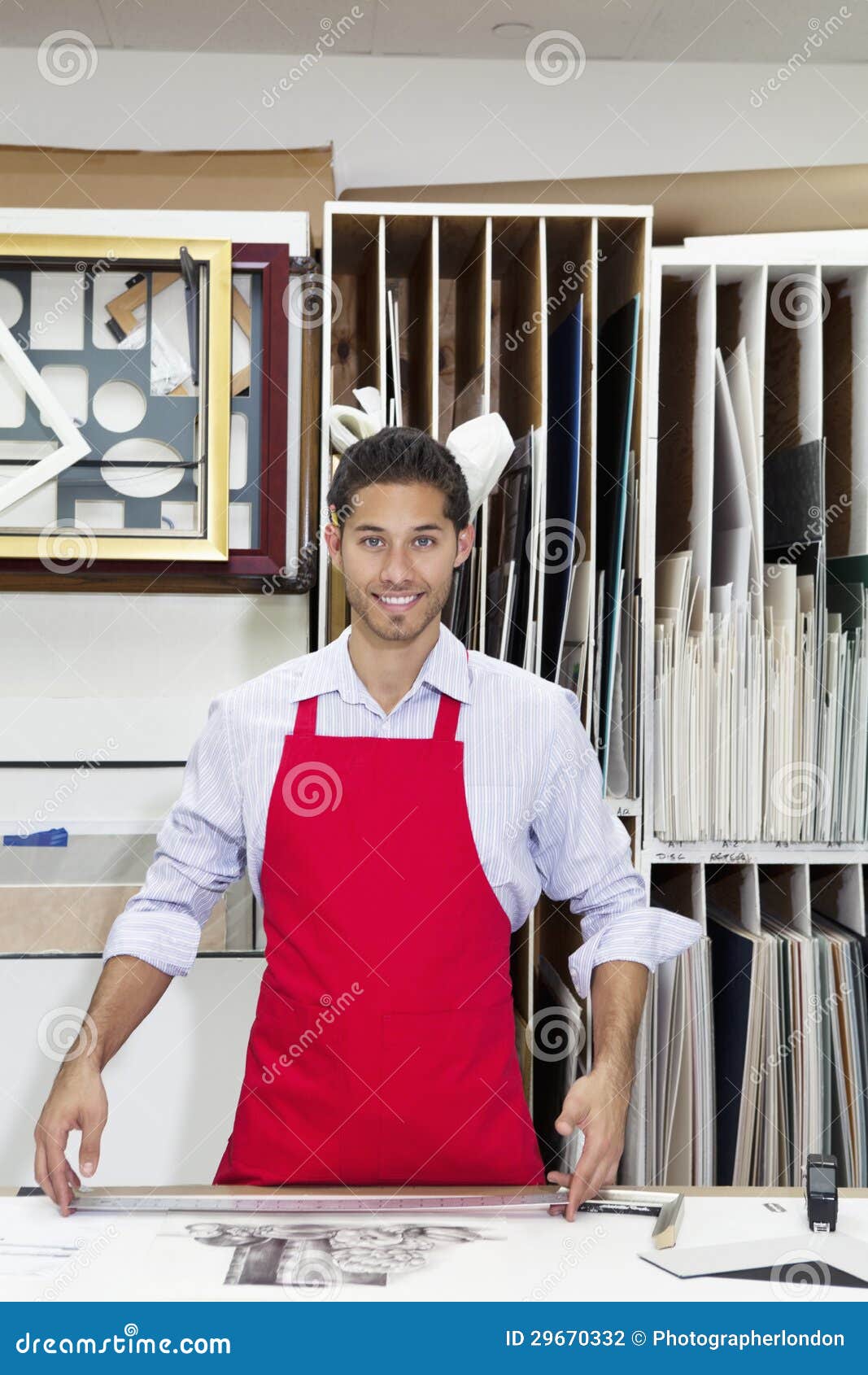 portrait of a happy young skilled worker standing with meter stick in workshop