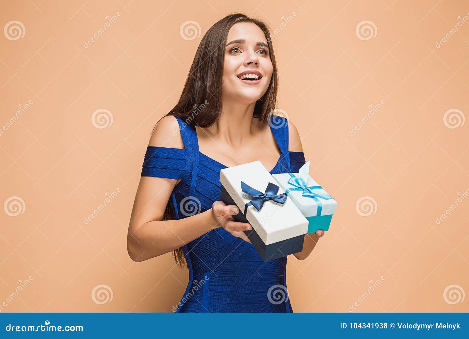 Portrait of Happy Young Woman Holding a Gifts on Brown Stock Photo ...