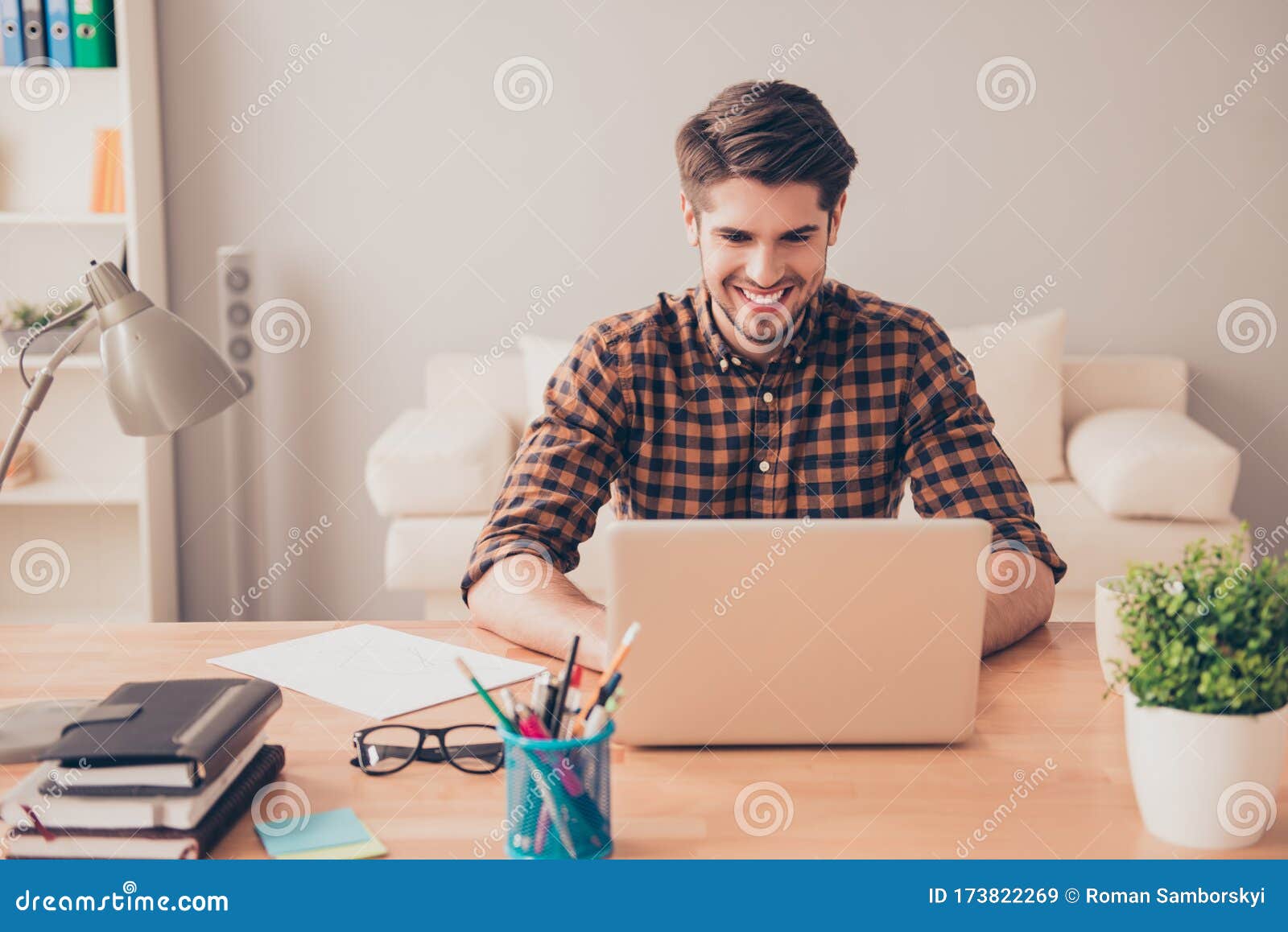 portrait of happy young writer typing new book on laptop