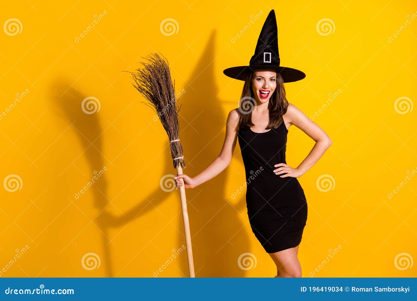 Portrait of her she nice-looking attractive pretty slender cheerful cheery lady wizard holding in hand broom magic. Portrait of her she nice-looking attractive pretty slender cheerful cheery lady, wizard holding in hand broom magic season event isolated bright vivid shine vibrant yellow color background