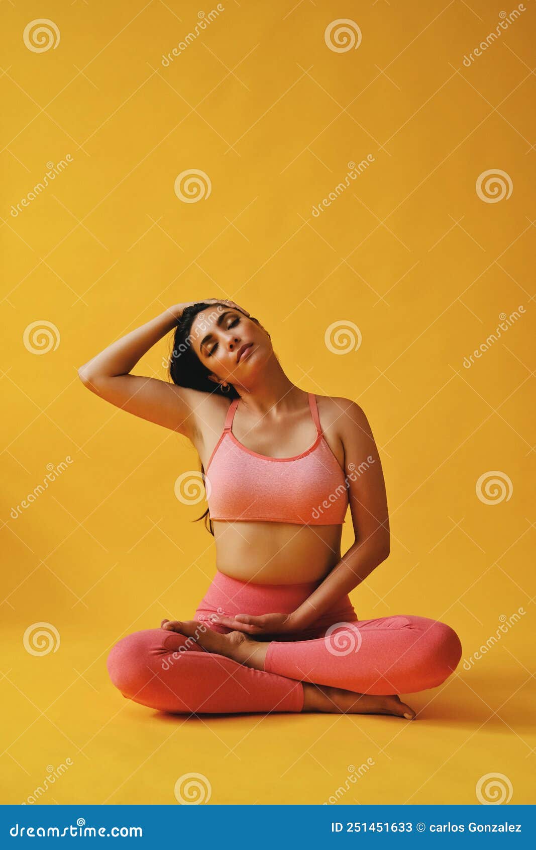 Meditating woman sitting cross-legged on edge of balcony stock photo -  OFFSET