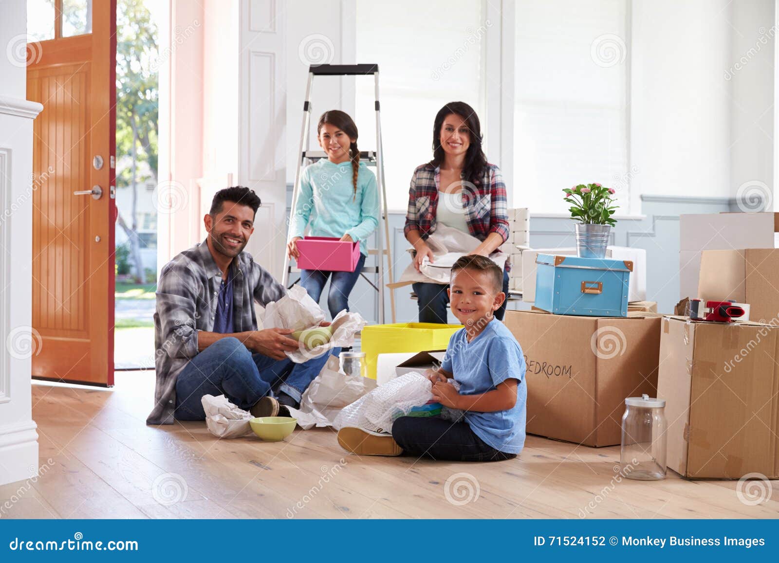 portrait of hispanic family moving into new home
