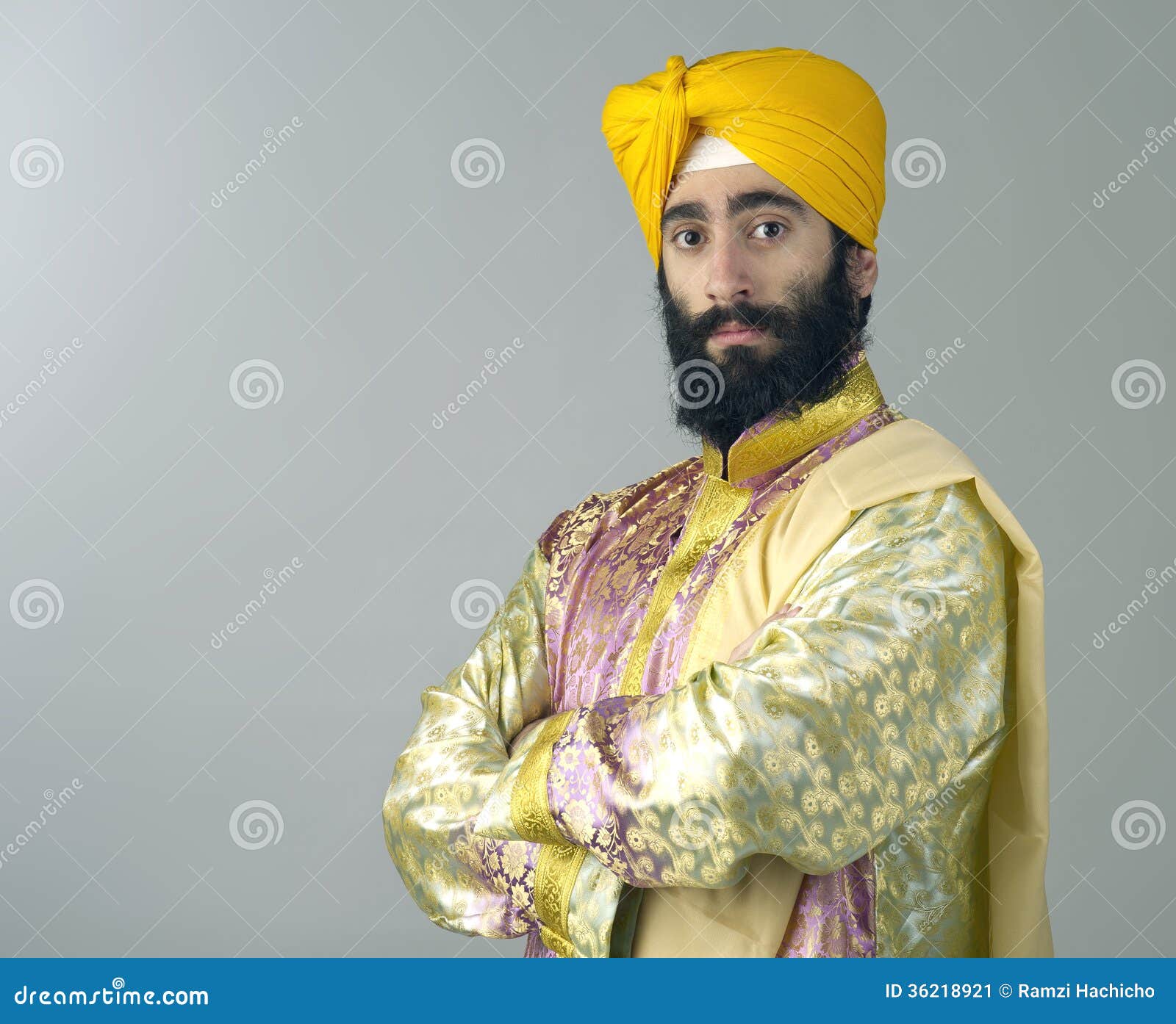 portrait of indian sikh man with bushy beard with his arms crossed