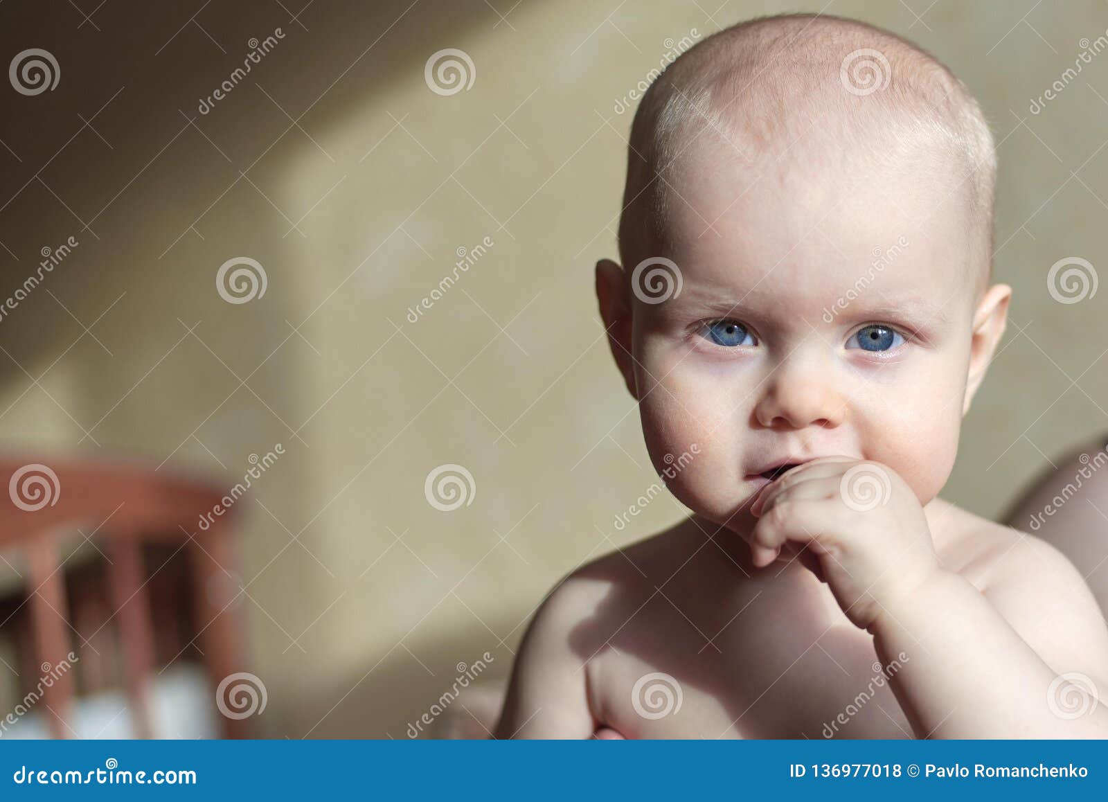 Portrait Of Sad Charming Baby With Finger In His Mouth 