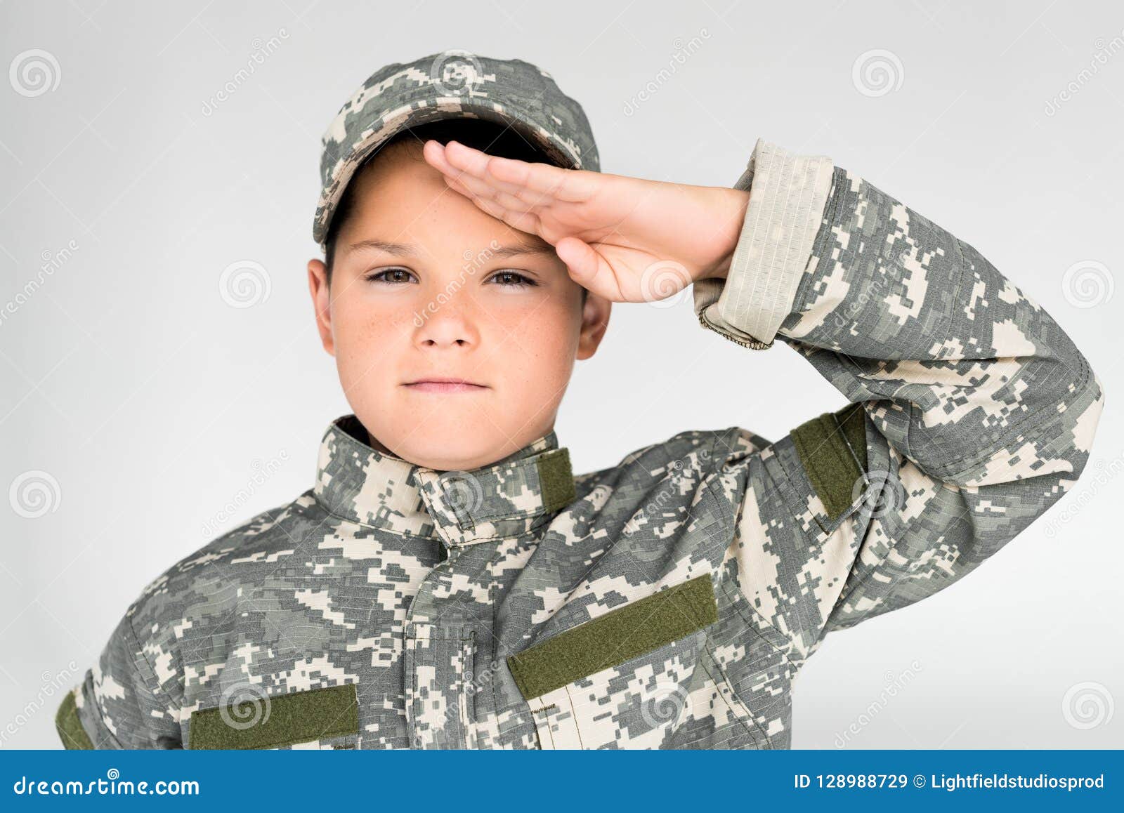 Portrait of Kid in Military Uniform Looking at Camera and Saluting