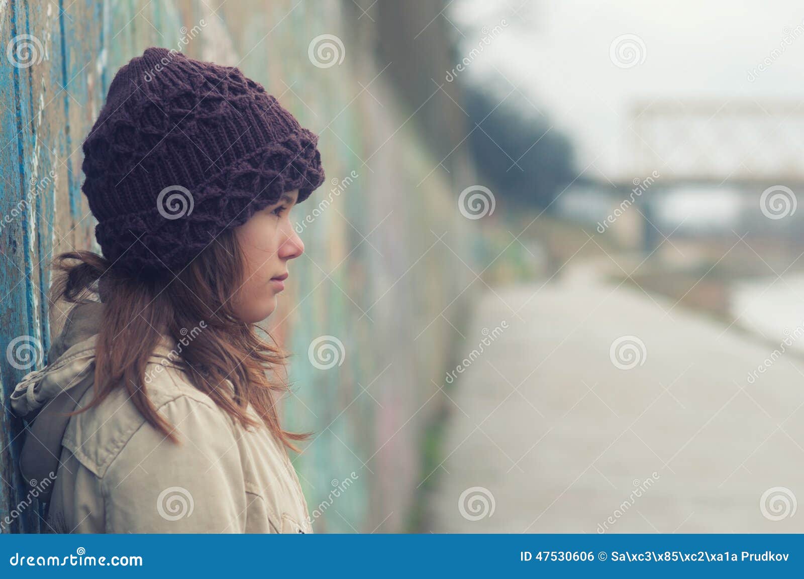 portrait of lonely teenage girl on moody winter day