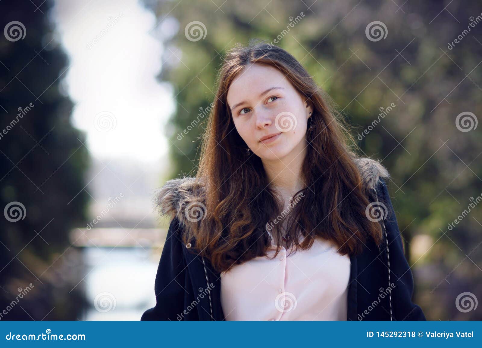 Portrait of a Long-haired Girl Standing Against the River and Forest ...