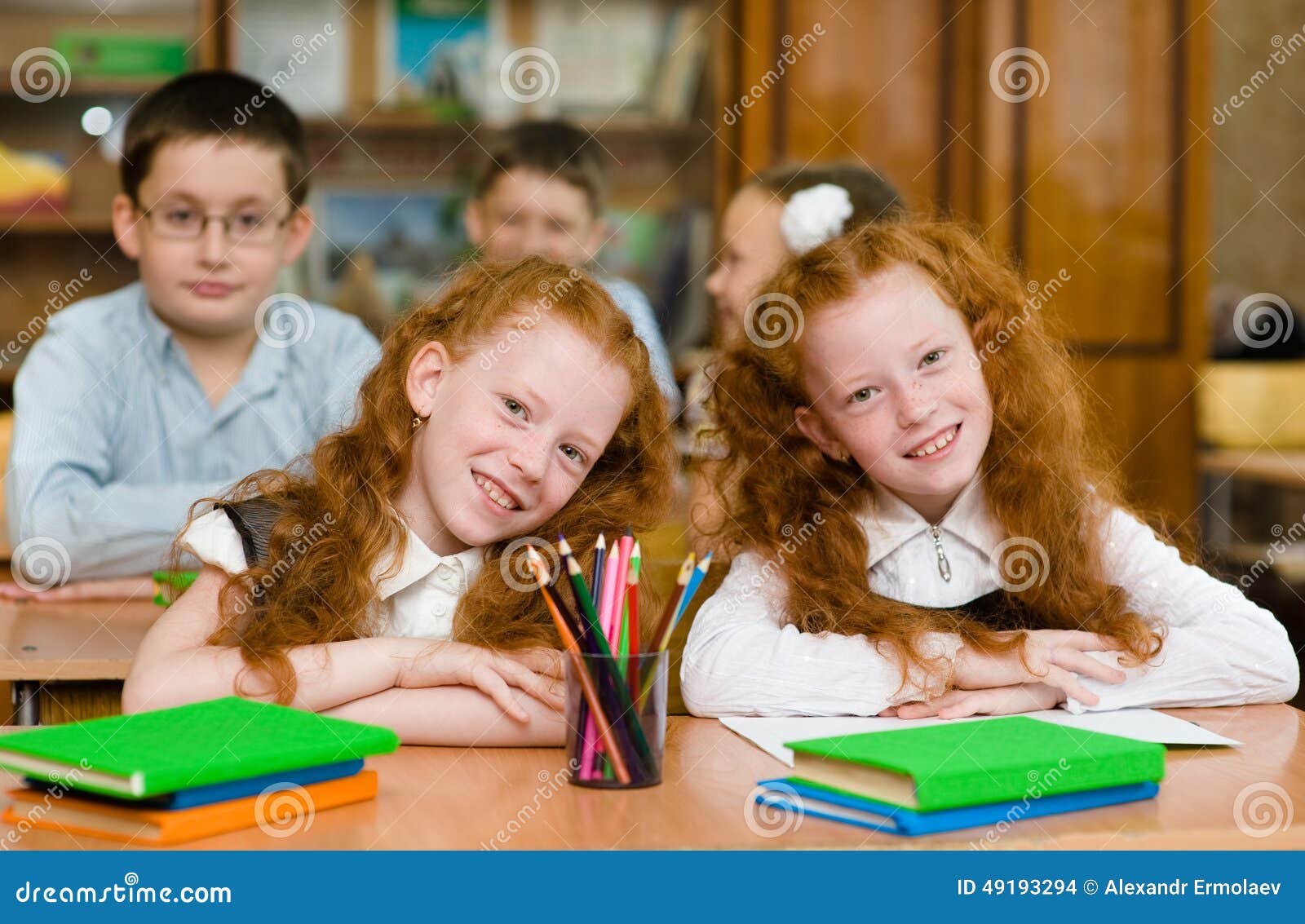 portrait of lovely twins girls with schoolboys on background. lo