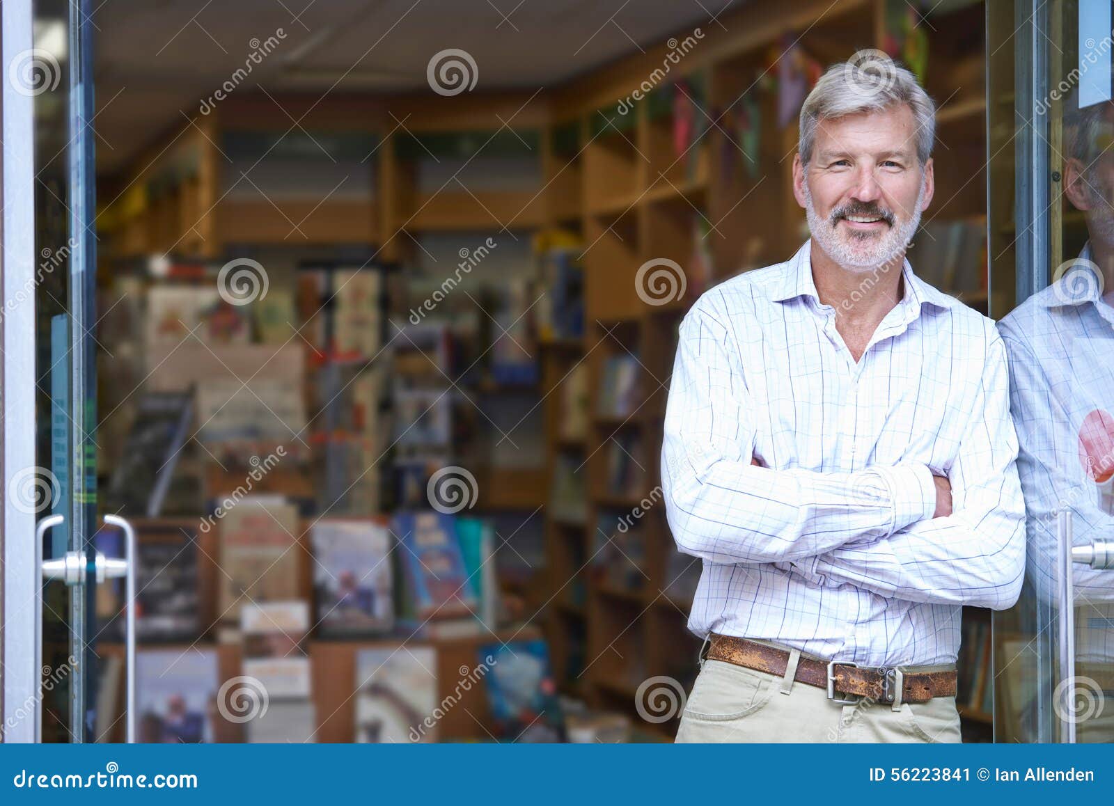 portrait of male bookshop owner outside store