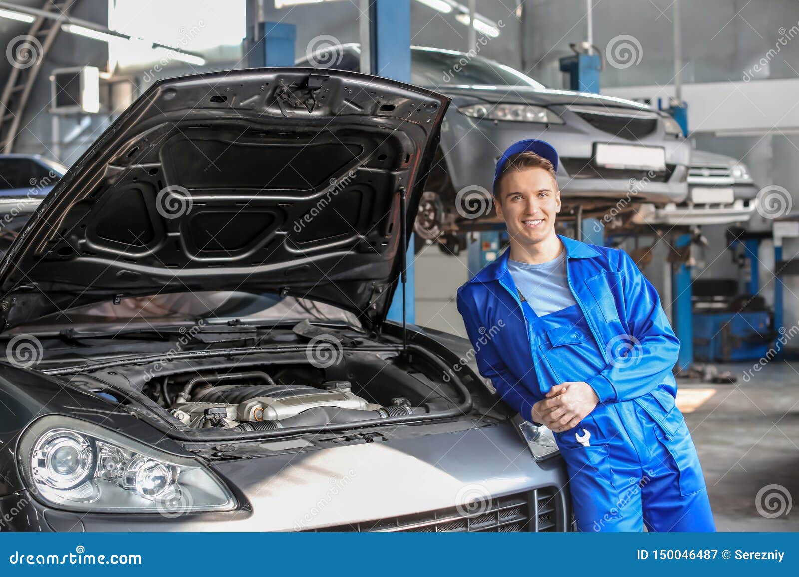 Portrait Of Male Mechanic Near Car In Service Center Stock Image
