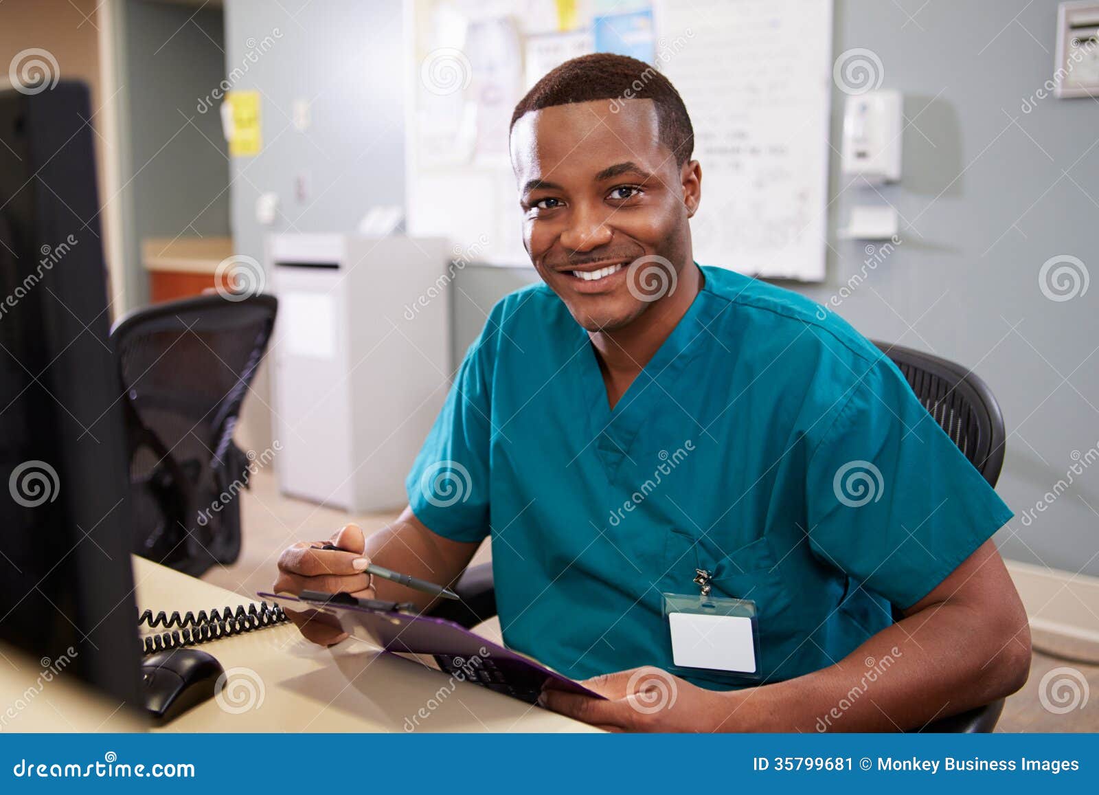 portrait of male nurse working at nurses station