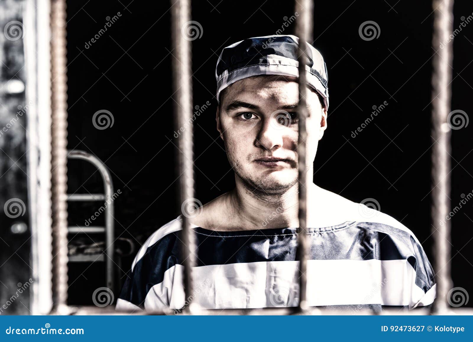 Portrait Of Male Prisoner Wearing Prison Uniform Standing Behind Stock Image