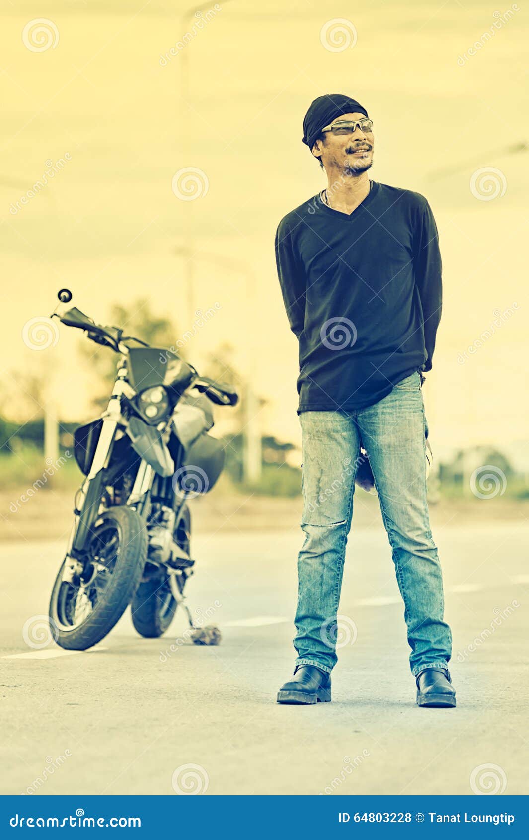 Portrait of Man Biker Standing on Road with Motorcycle Stock Photo