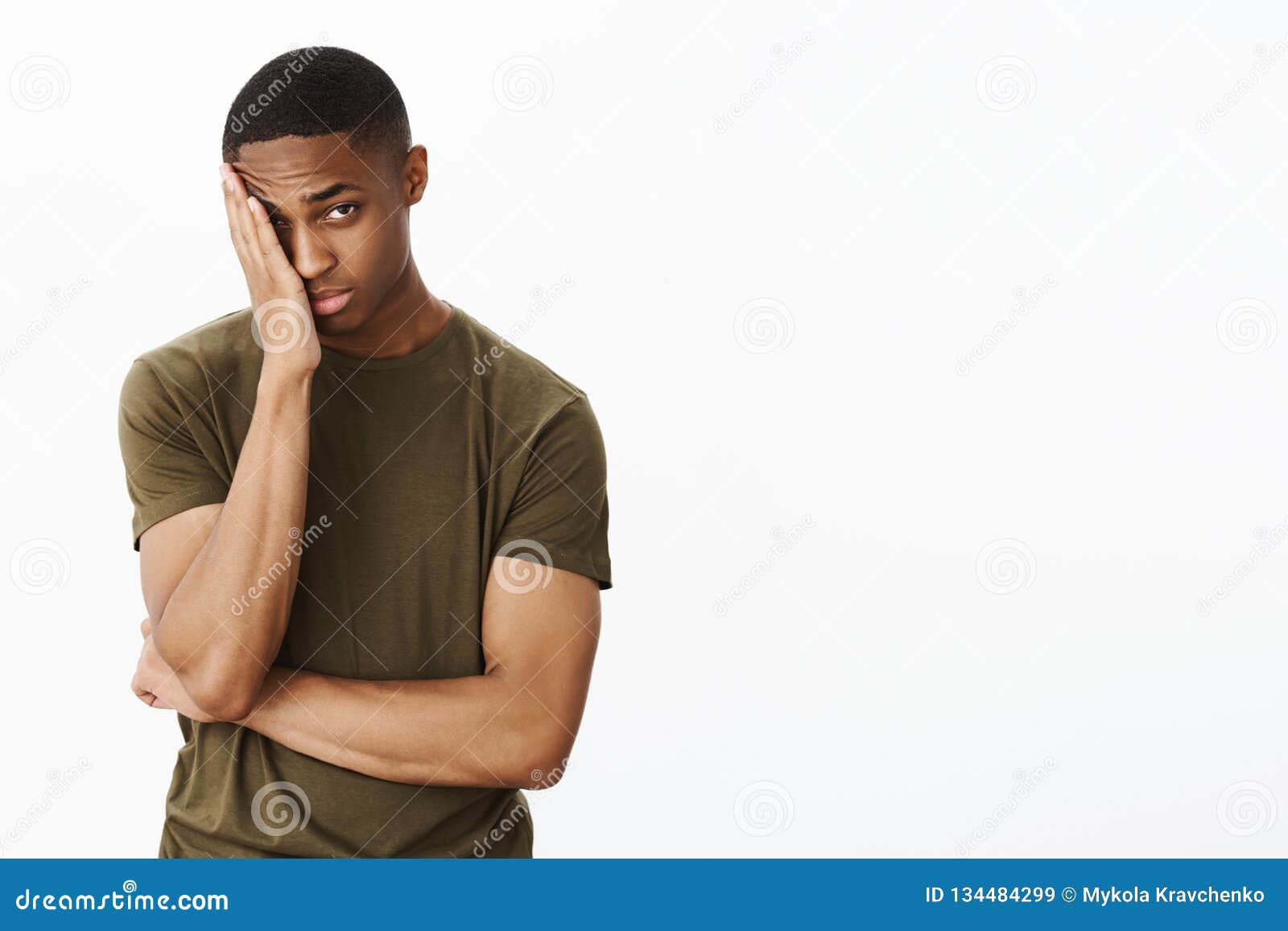 portrait of man feeling embarrassed making facepalm gesture putting hand to half of face peeking at camera with tired