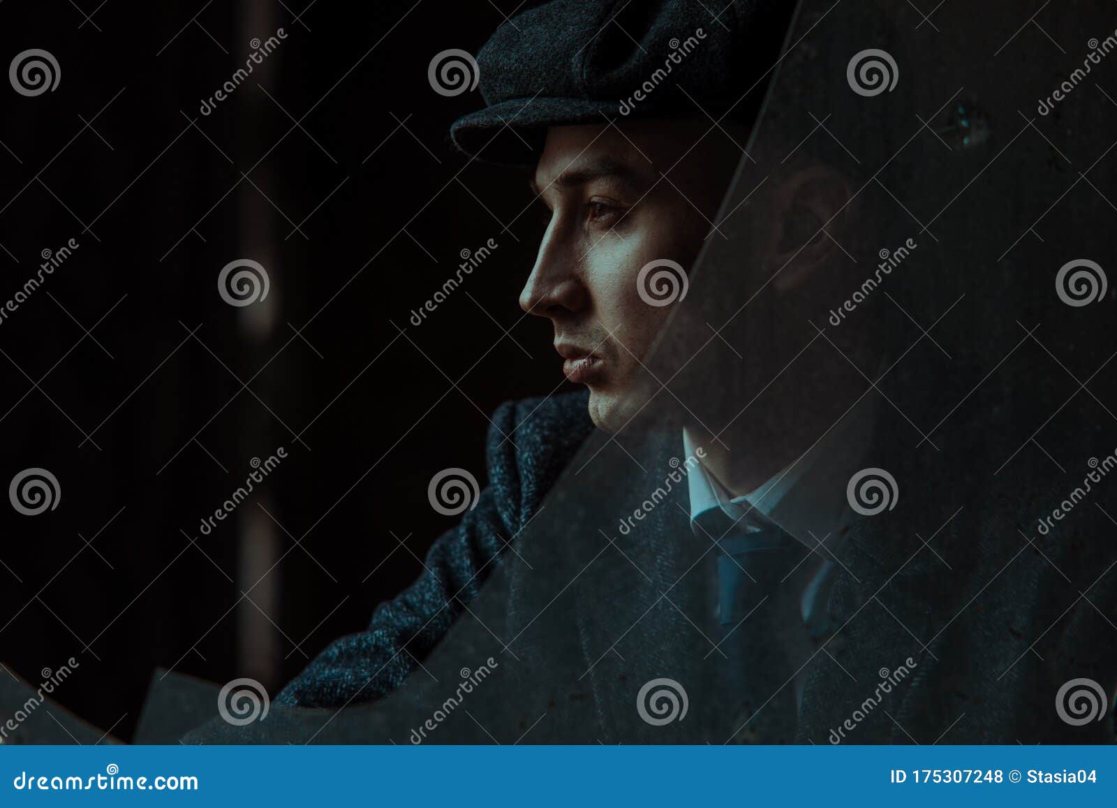 portrait of a man in the image of an english retro gangster in peaky blinders style through broken glass