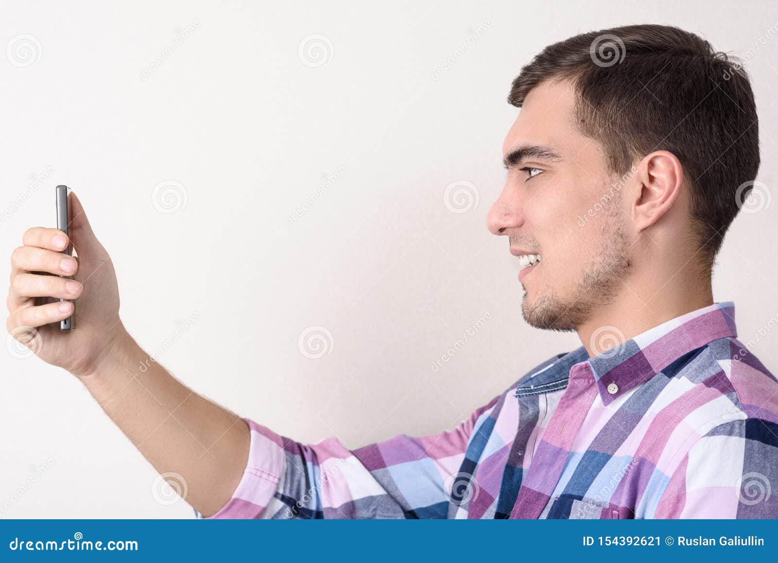 Portrait Of Man In Profile With Smartphone In His Hand, Uses The Face ...