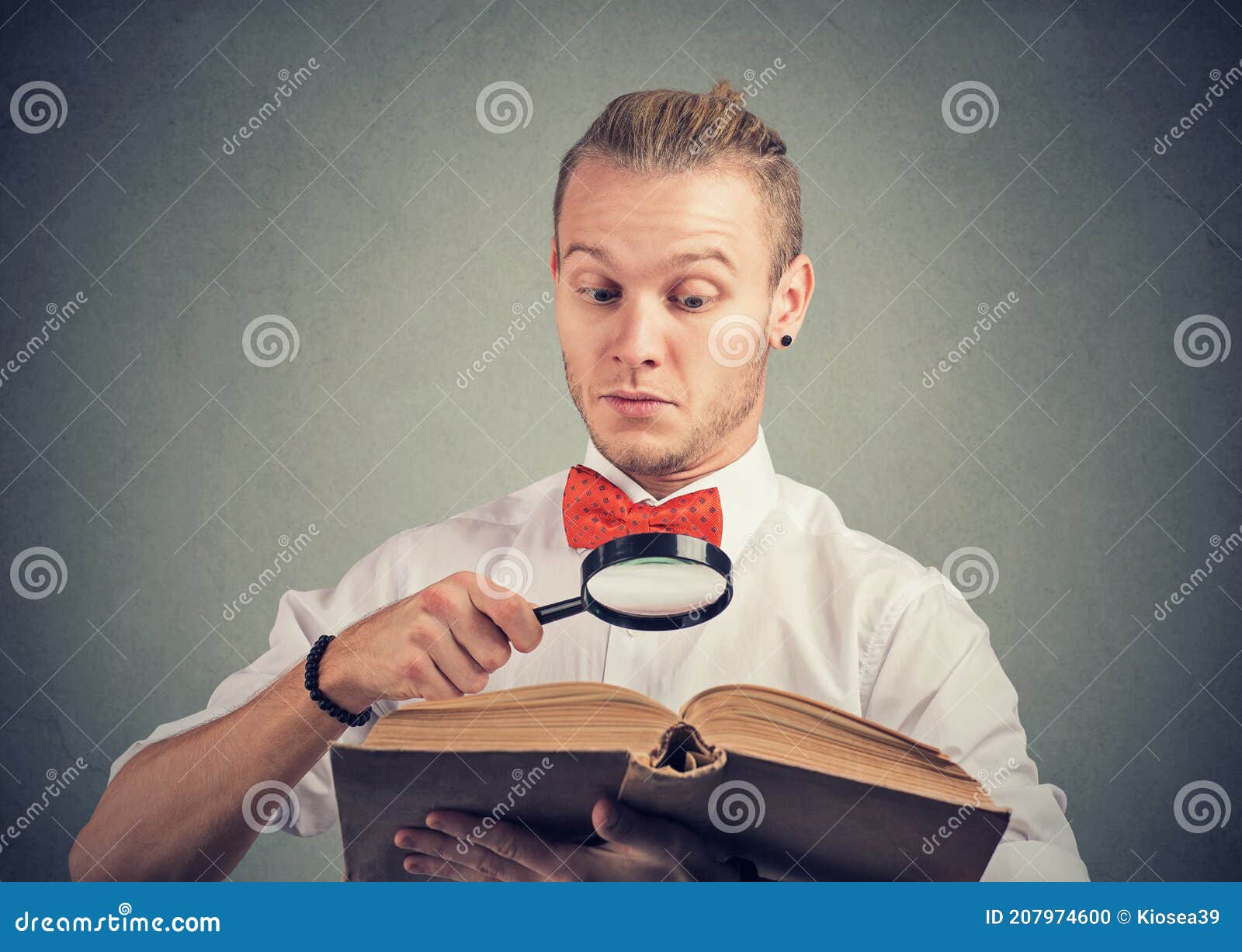 portrait of a man reading an interesting book with magnifying glass